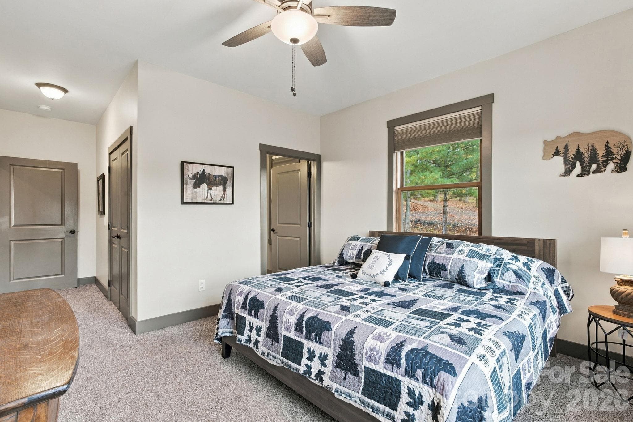 Spacious primary bedroom on the main floor with ceiling fan, double door closet, and plush carpet - 1206 River Stone Drive, Laurel Springs