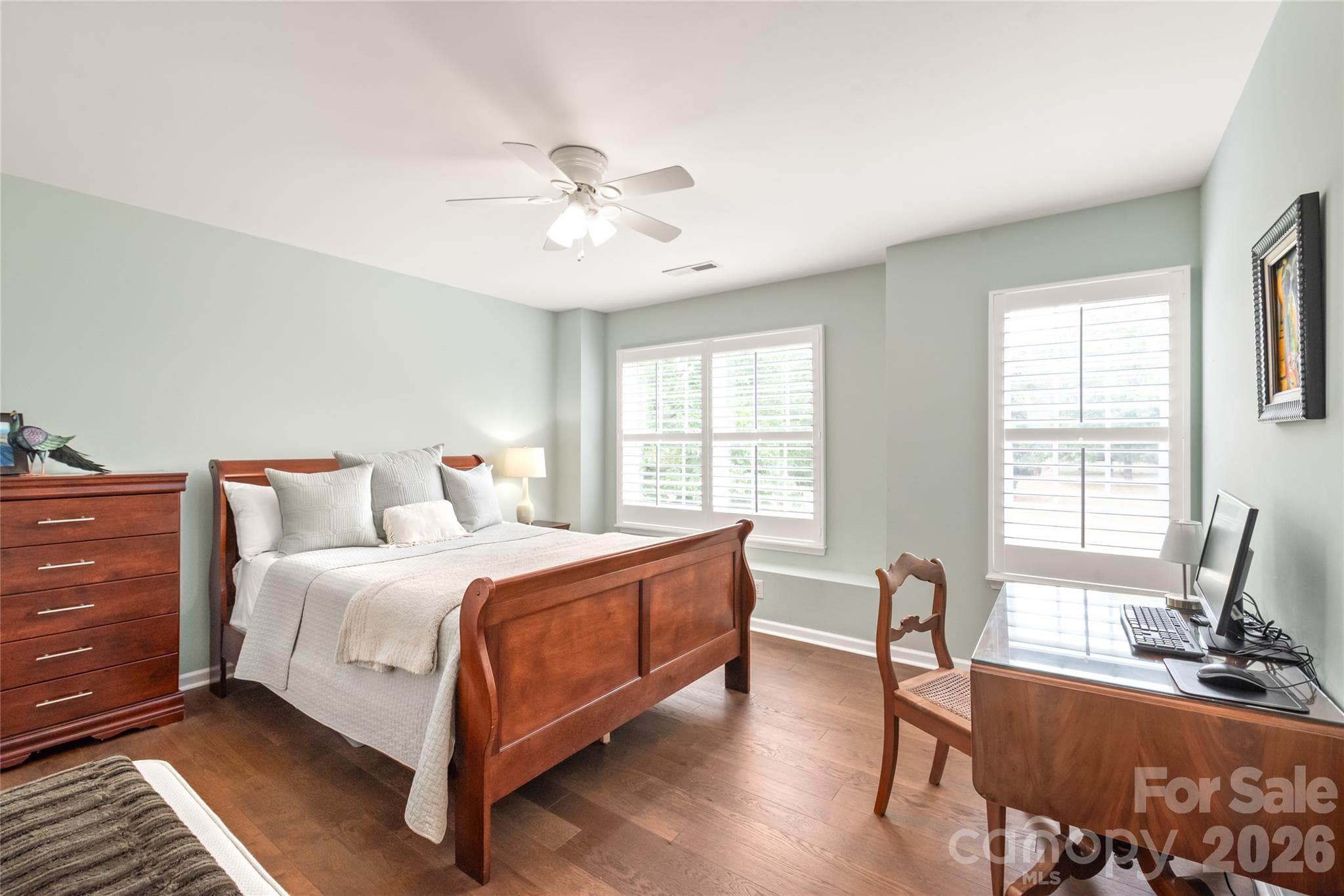 Clean, sleek, and carpet-free! Bedroom two features rich engineered hardwood flooring and elegant custom plantation shutters, bringing timeless style, privacy, and continuous warmth to the space. - 4780 Grier Farm Lane, Charlotte