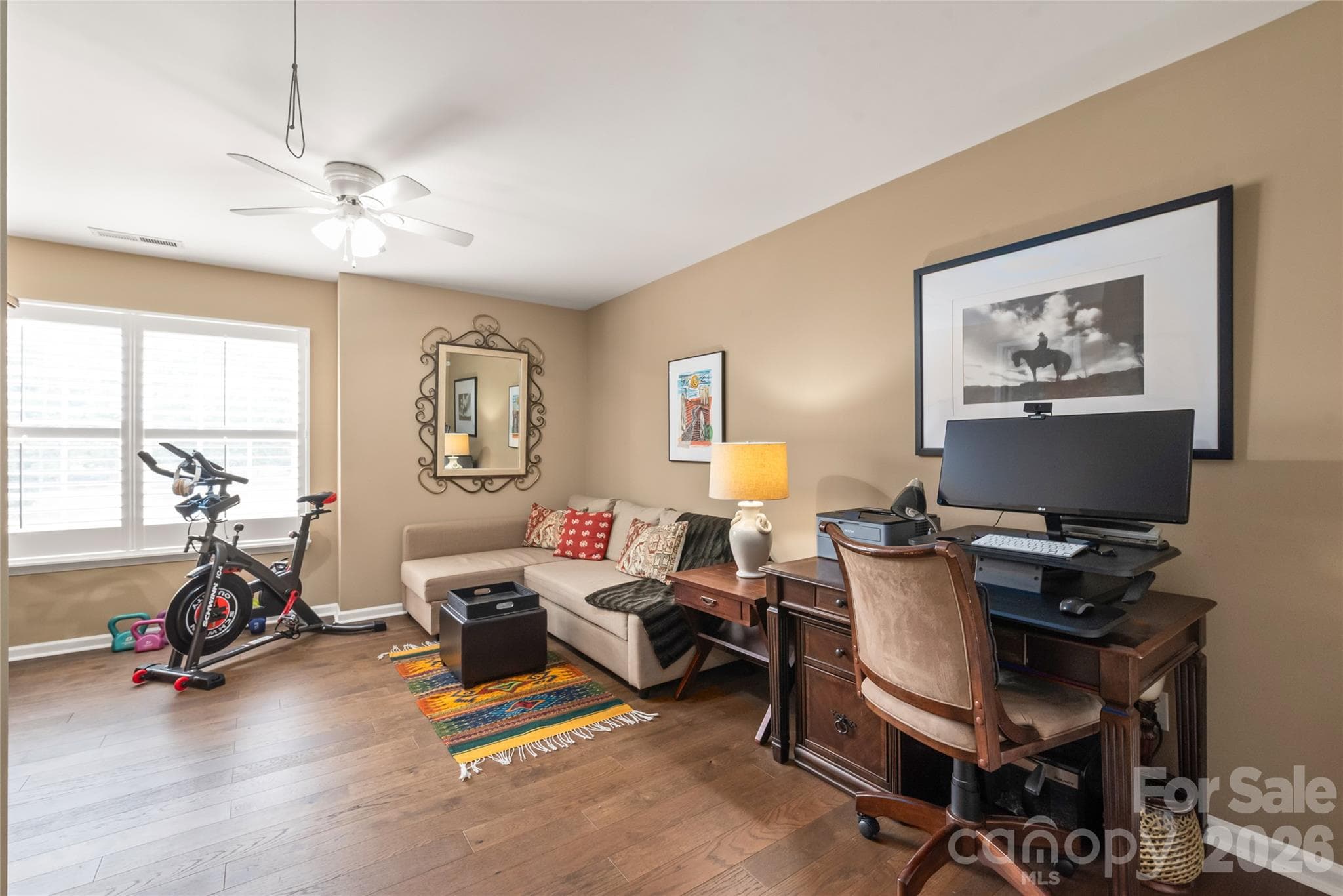 Style, space, and sunlight! Bedroom three shines with rich engineered hardwood floors, a spacious walk-in closet, and custom plantation shutters for total light control and privacy. - 4780 Grier Farm Lane, Charlotte