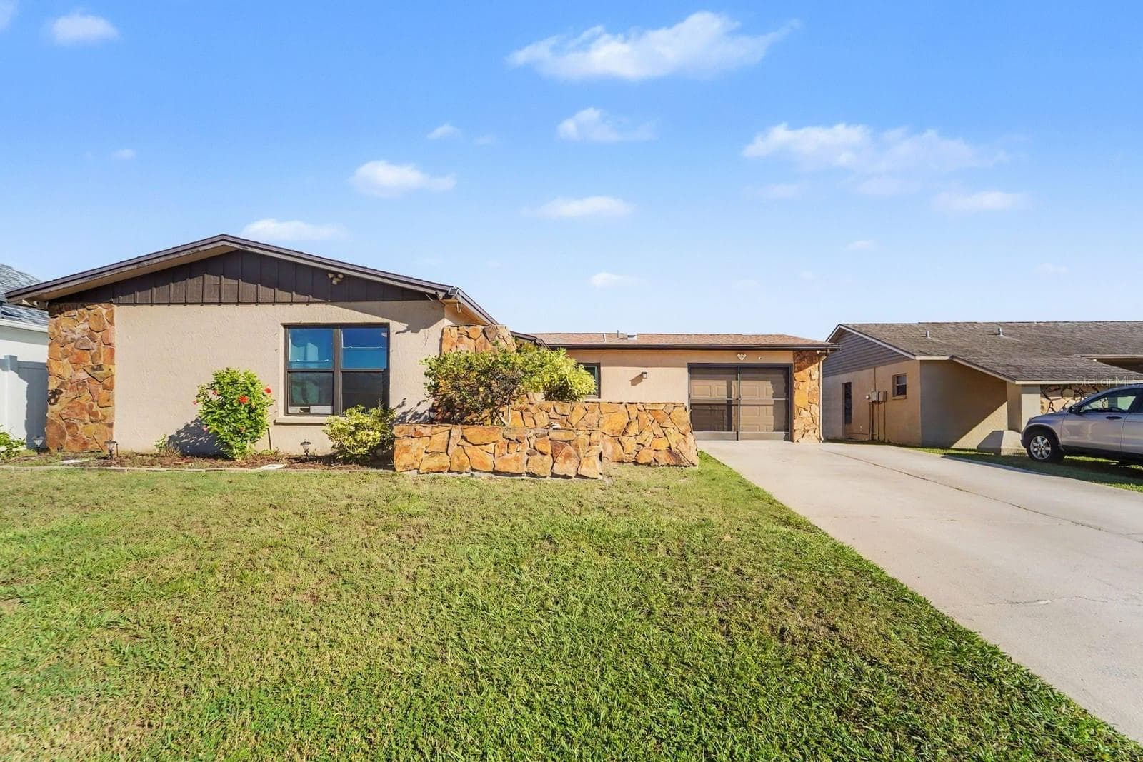 Stone & stucco contemporary home with manicured lawn and attached garage - 8431 REDFIELD DR, PORT RICHEY