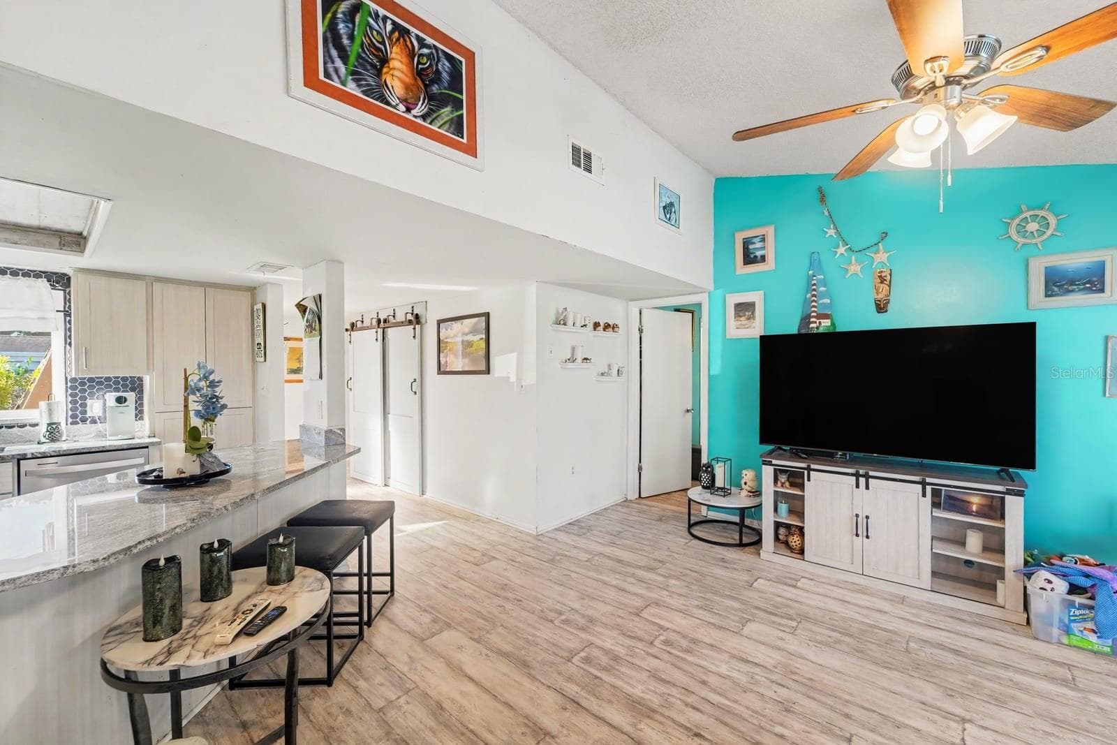 Open-Concept Living With Turquoise Accent Wall & Modern Entertainment Setup - 8431 REDFIELD DR, PORT RICHEY