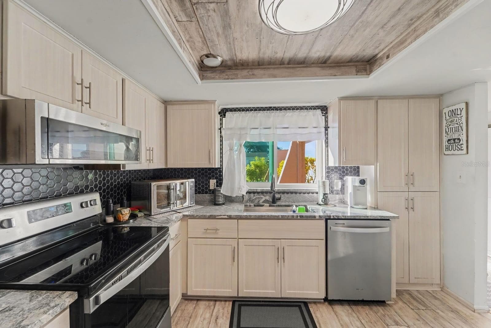 Bright Kitchen With Cream Cabinetry, Black Hexagon Tile & Window Views - 8431 REDFIELD DR, PORT RICHEY