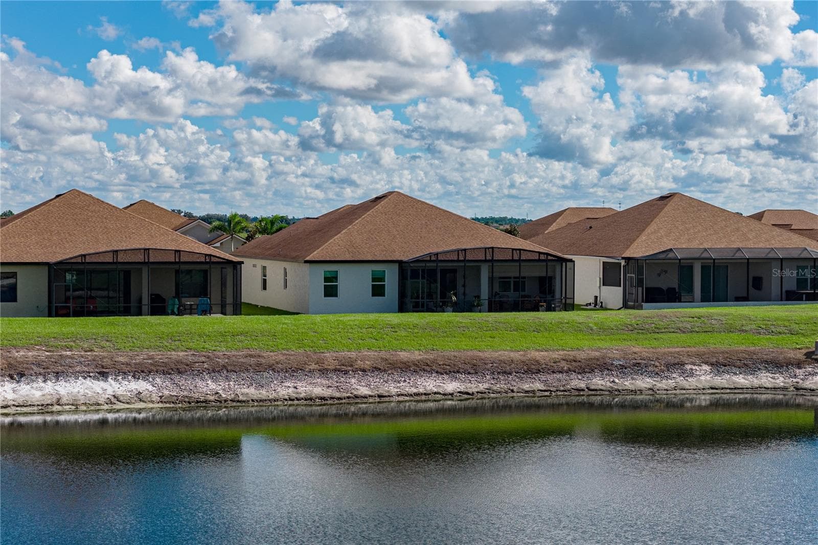House drone view from pond - 6125 PEBBLE BEACH BLVD, WINTER HAVEN