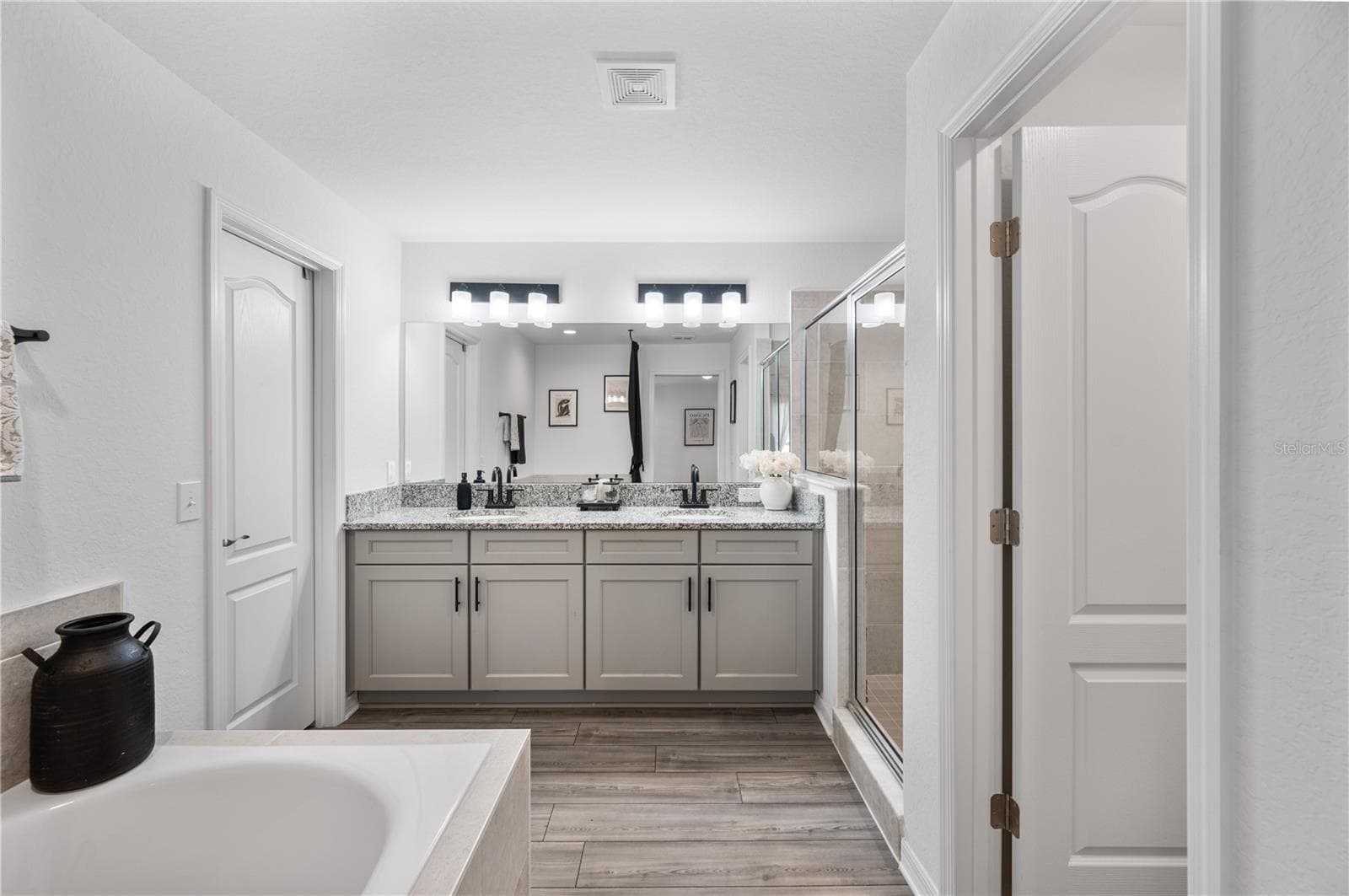 The Primary en suite bathroom features a large walk in closet, walk-in shower, soaking tub & private commode area & oversized dual sinks vanity - 1279 PINTAIL PL, LAKELAND