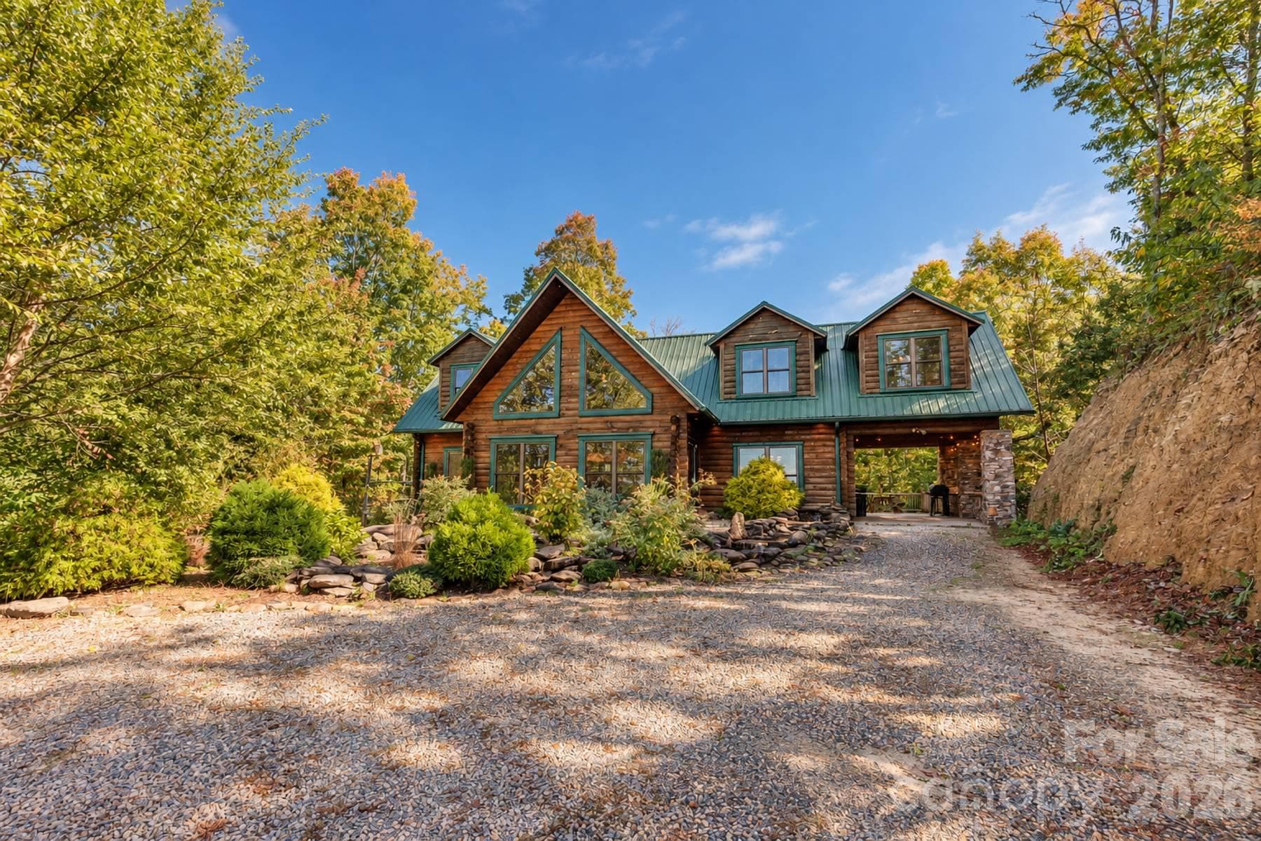 Front exterior with gable windows, green metal roof and carport - 18 Fairway Run, Bryson City