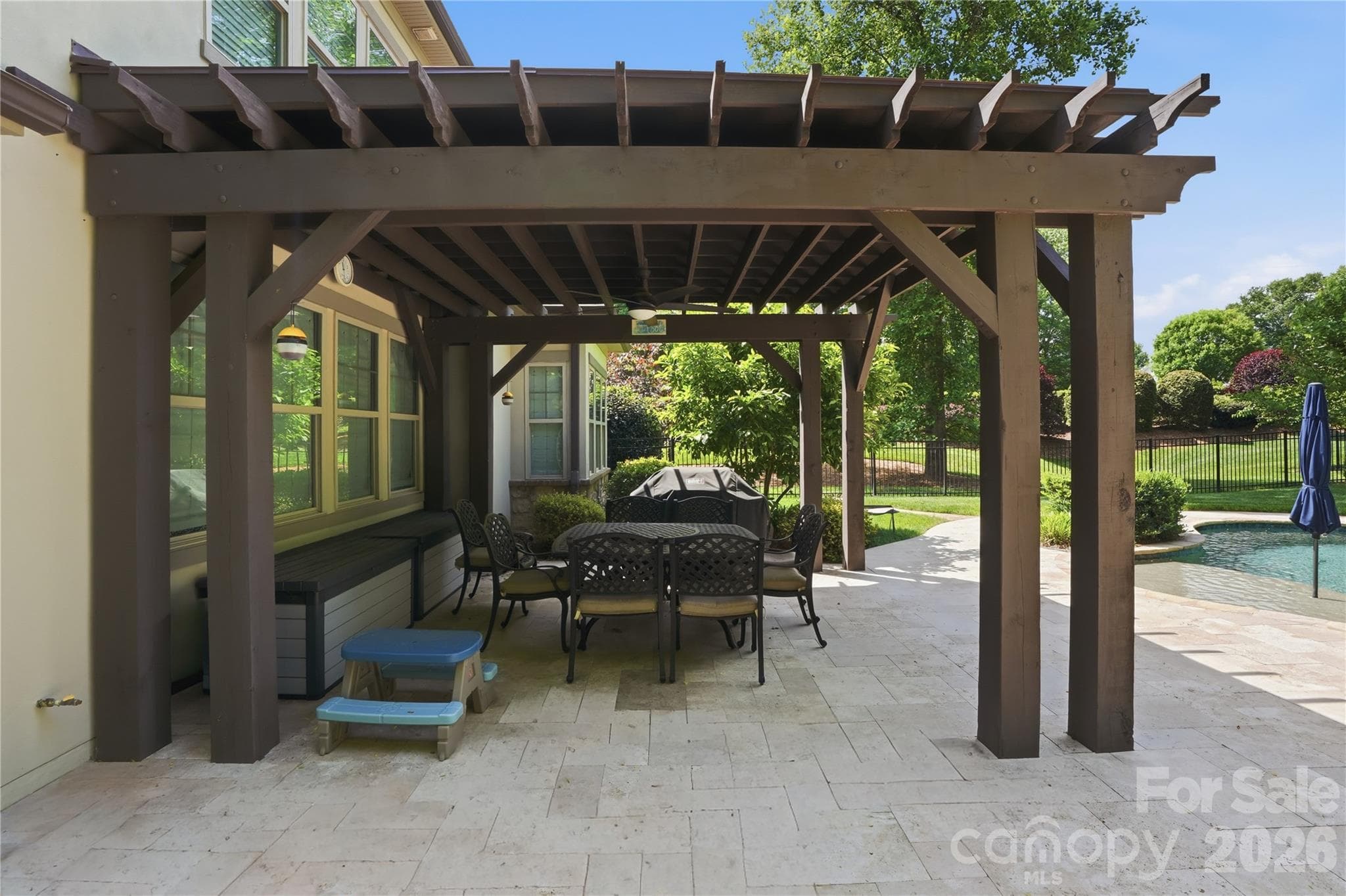 covered pergola and travertine patio surrounding Pebble Tech pool and spa - 13632 Castleford Drive, Mint Hill