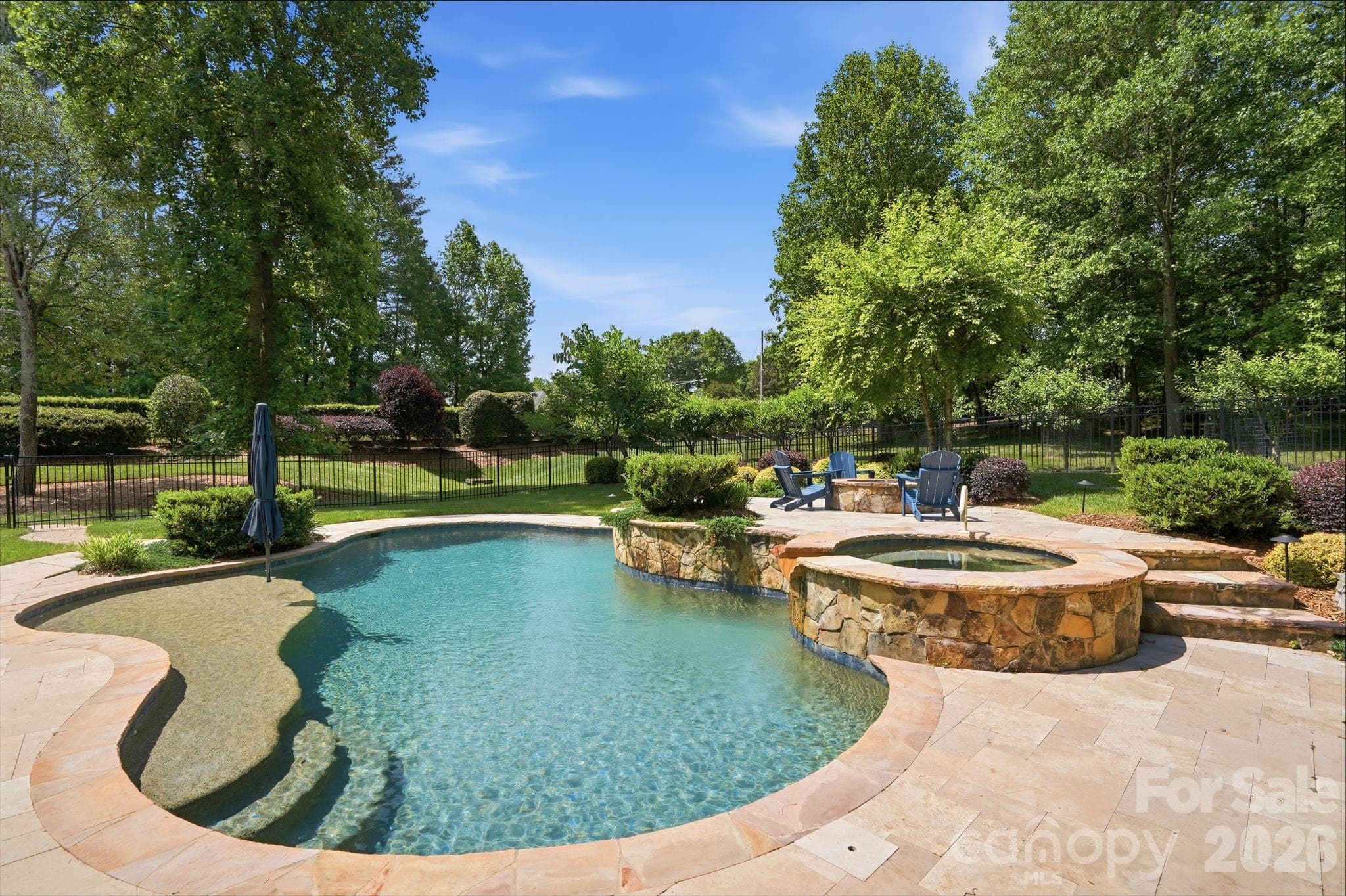 heated Pebble Tech pool and spa with waterfalls and sundeck as well as a gas fire pit. - 13632 Castleford Drive, Mint Hill