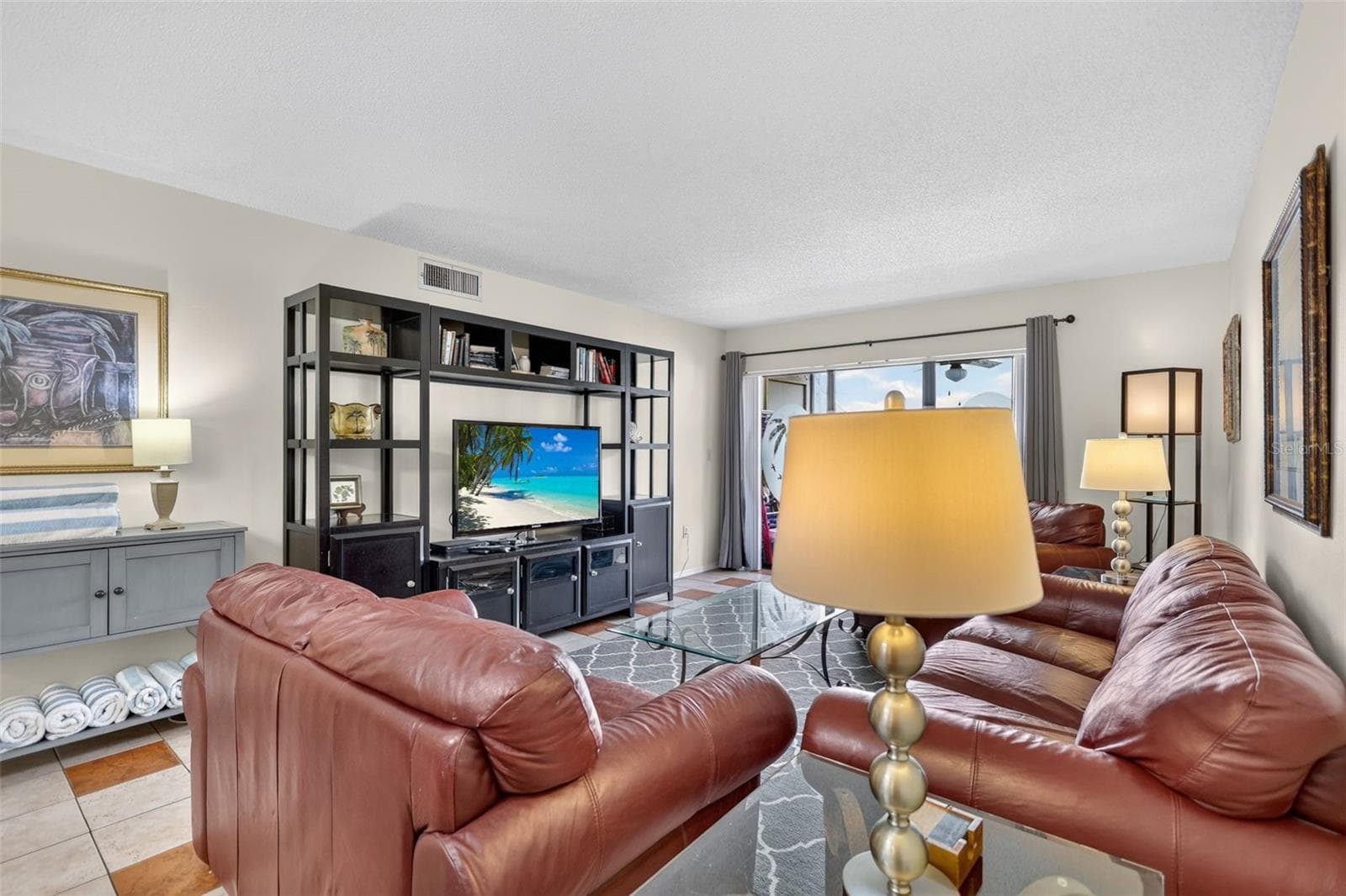 Spacious living room featuring an open-concept layout and a dedicated entertainment area. - 6157 MIDNIGHT PASS RD #E53, SARASOTA