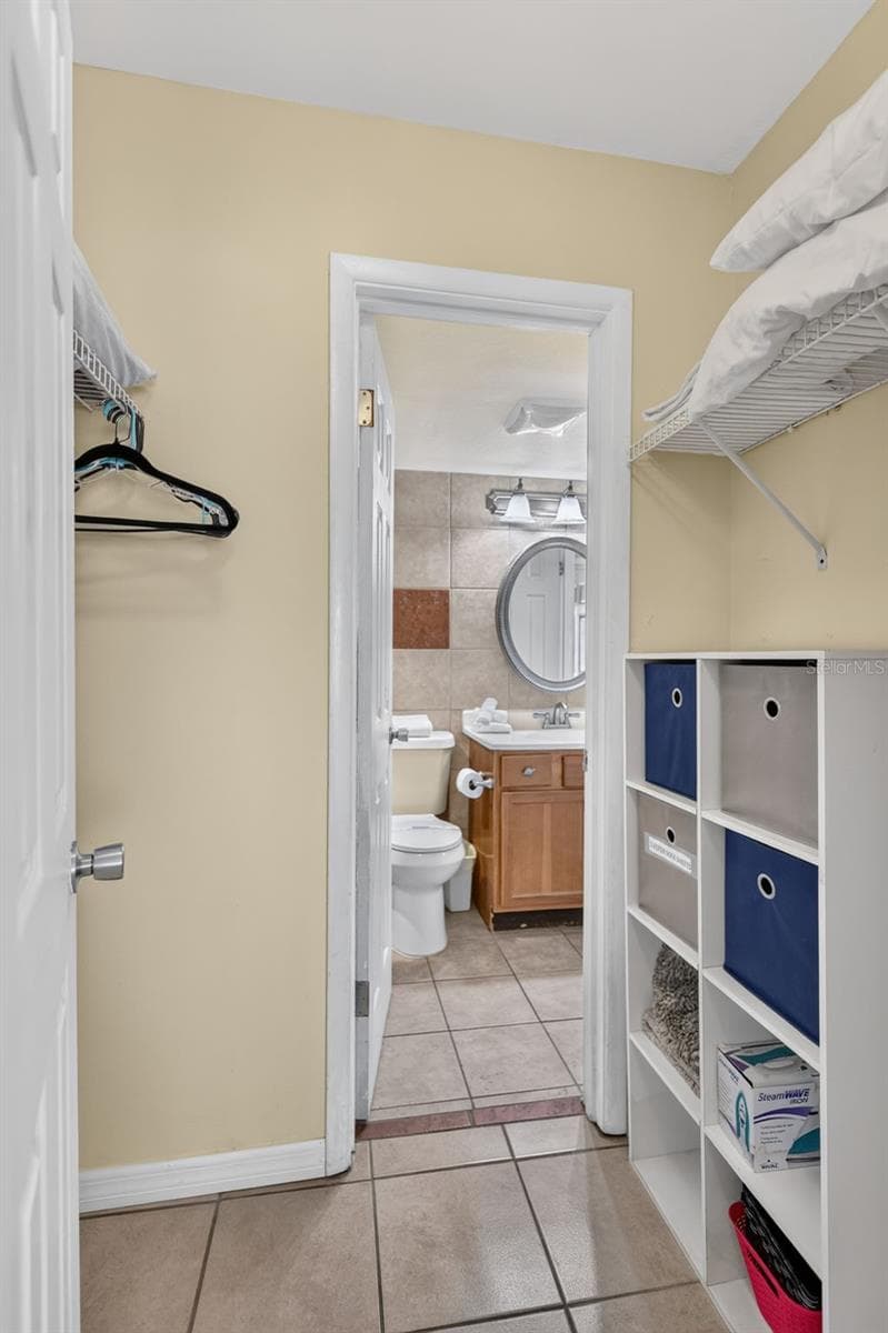 Large walk-in closet for the guest bedroom, with direct access to the bathroom. - 6157 MIDNIGHT PASS RD #E53, SARASOTA