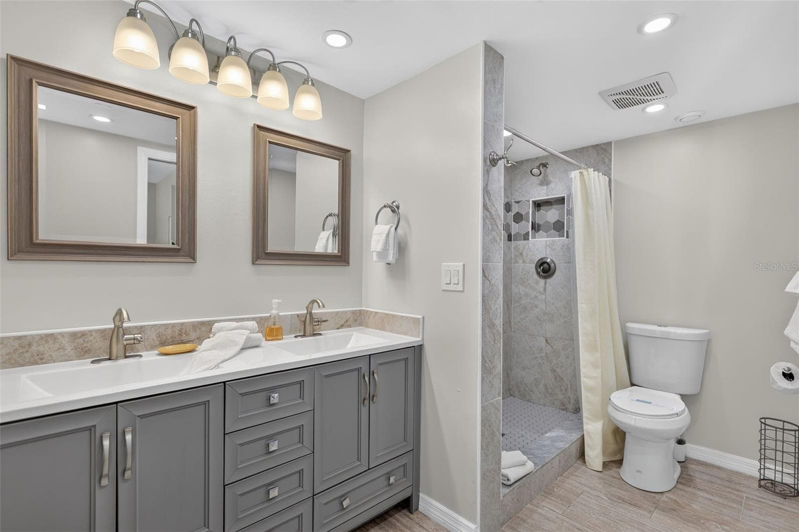 Primary bathroom featuring a modern dual-sink vanity and a spacious walk-in tiled shower. - 6157 MIDNIGHT PASS RD #E53, SARASOTA