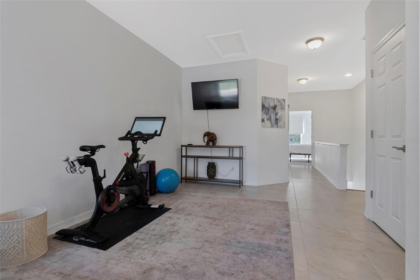 Versatile upstairs loft with tile flooring, currently used as a workout area. - 2455 GOLDEN PASTURE CIR, CLEARWATER
