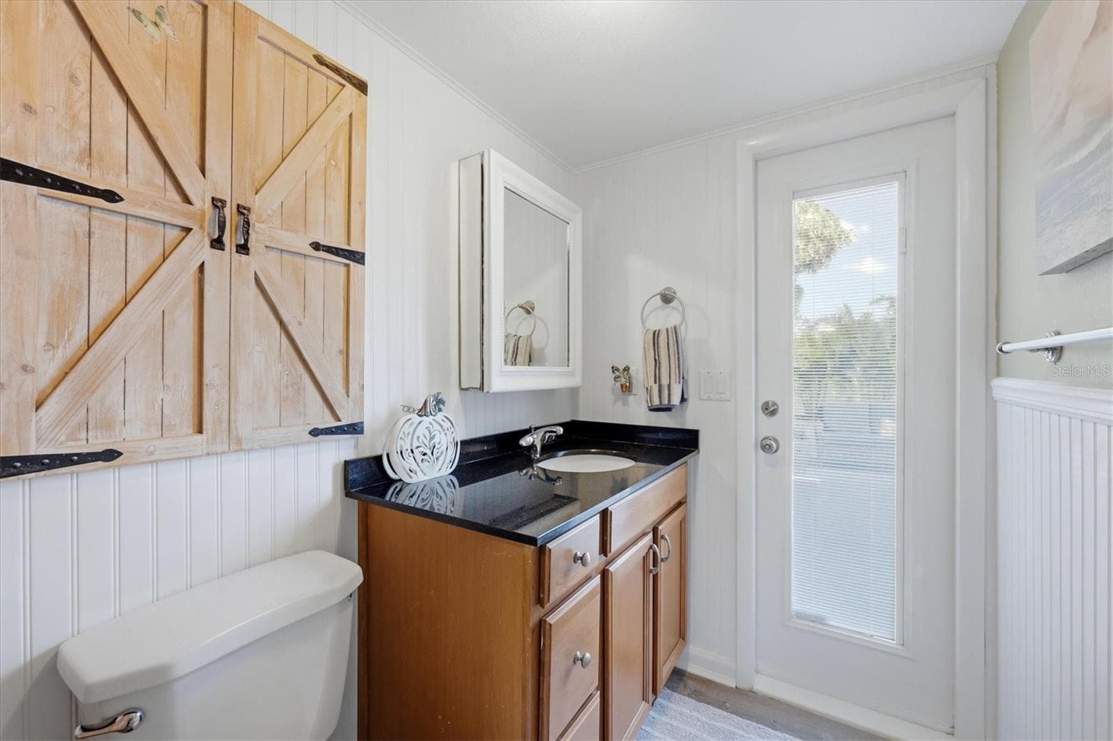 The bathroom adjacent to flex room offers an exterior door leading to the patio - 90 OAKLAND HILLS CT, ROTONDA WEST