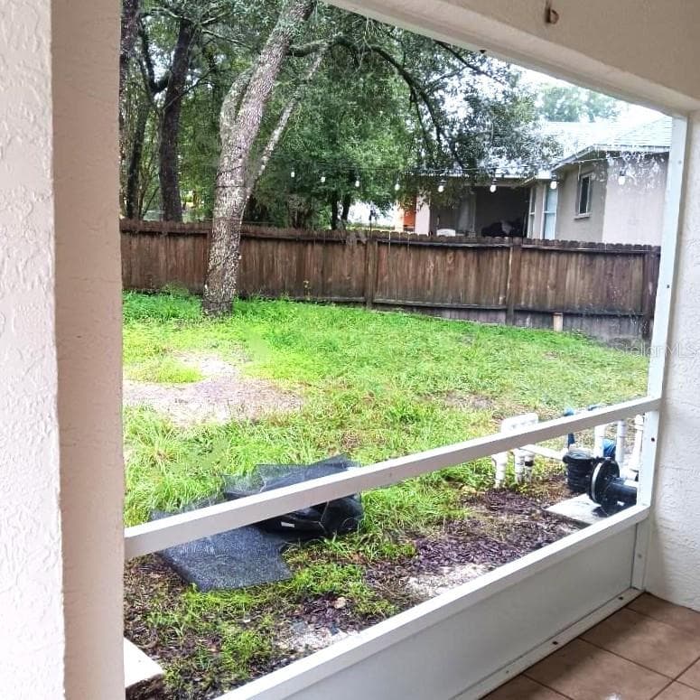 Looking out sliding doors from dining area across lanai to fenced back yard. - 8919 N MENDOZA WAY, CITRUS SPRINGS