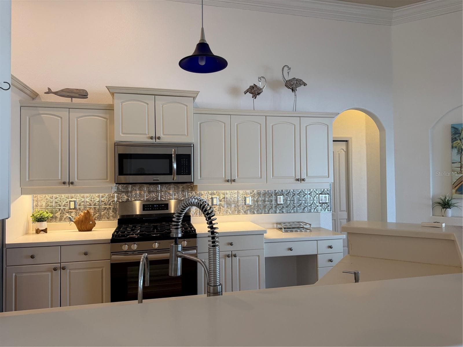decorative metal tiles adorn the wall under cabinets - 2311 OASIS DR, LAND O LAKES