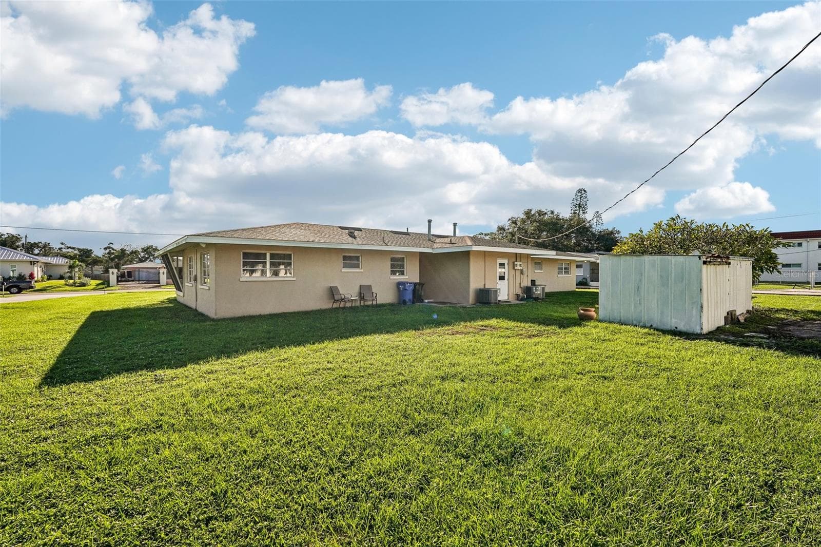 Back of duplex, shared laundry / utility room in center, plus two storage sheds. Oversized lot with a third of an acre! - 309 PARKSIDE DR, VENICE
