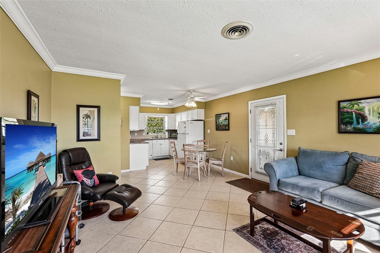 309 - Open plan living room, casual dining adjoining kitchen. Door leads to carport. - 309 PARKSIDE DR, VENICE