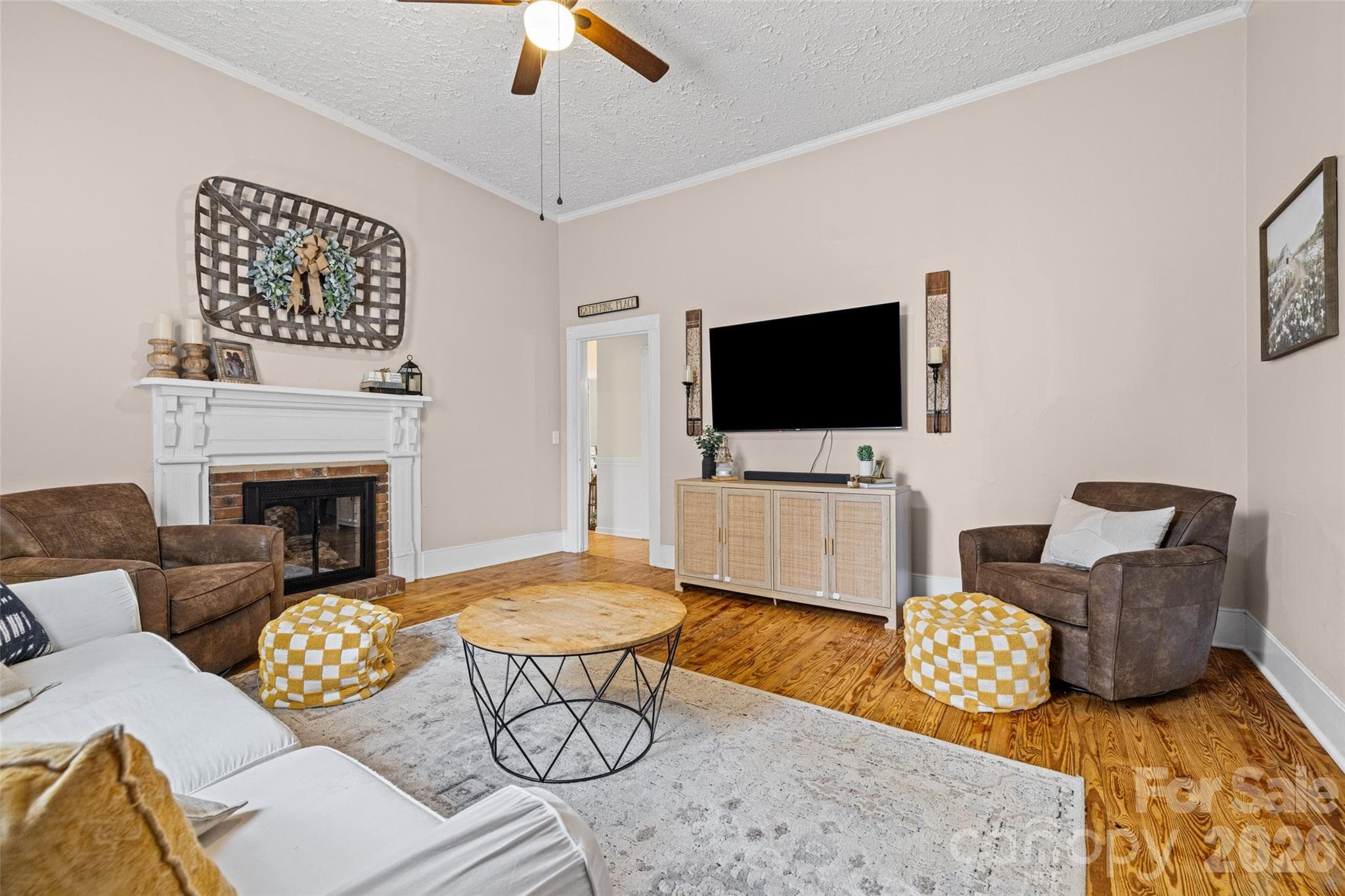 Bright and spacious living room featuring a decorative fireplace, beautiful hardwood floors, and timeless architectural details. - 231 E Jefferson Street, York
