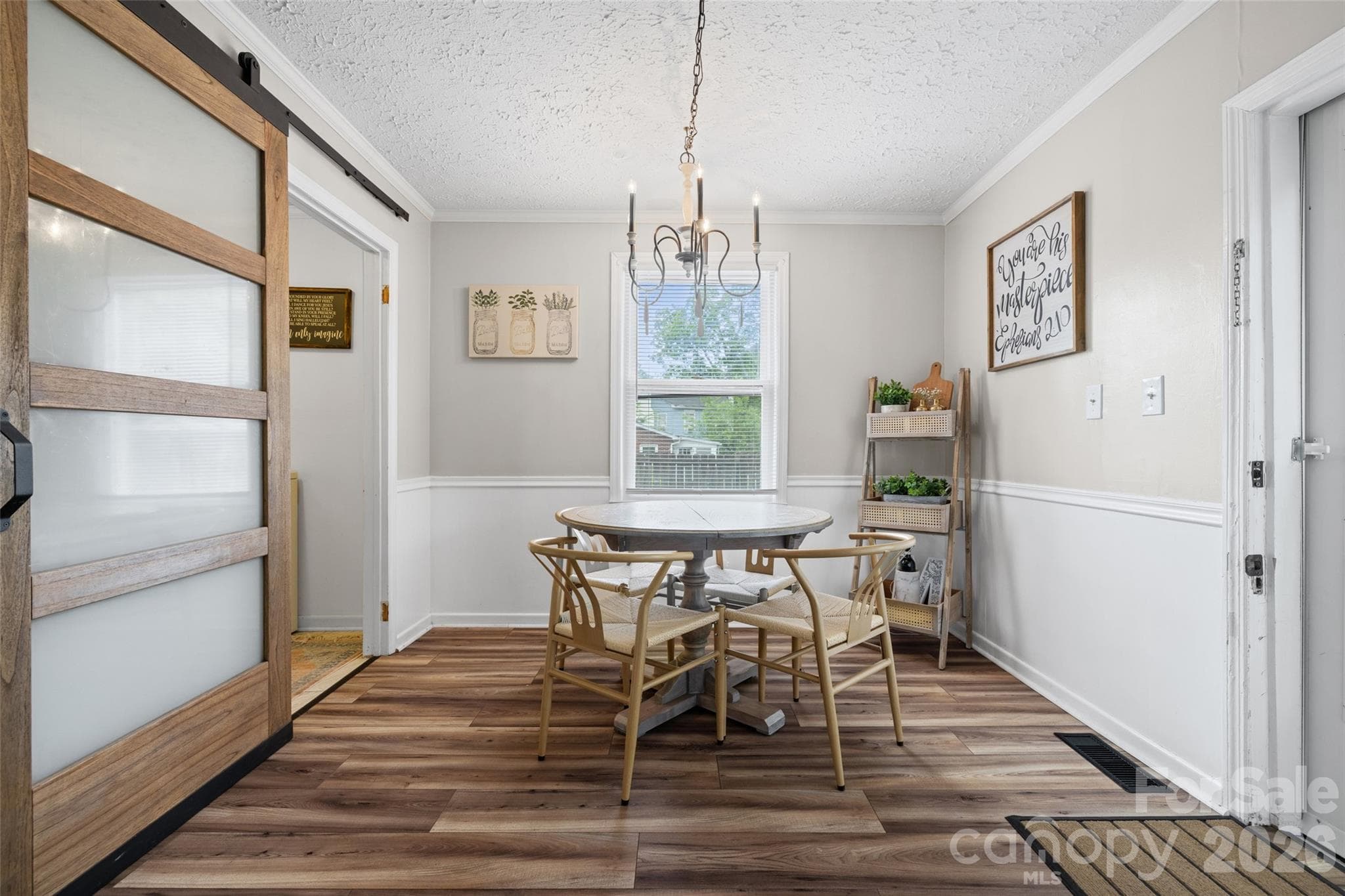 Another view of the dining space featuring updated flooring, classic wainscoting, and plenty of natural light. - 231 E Jefferson Street, York