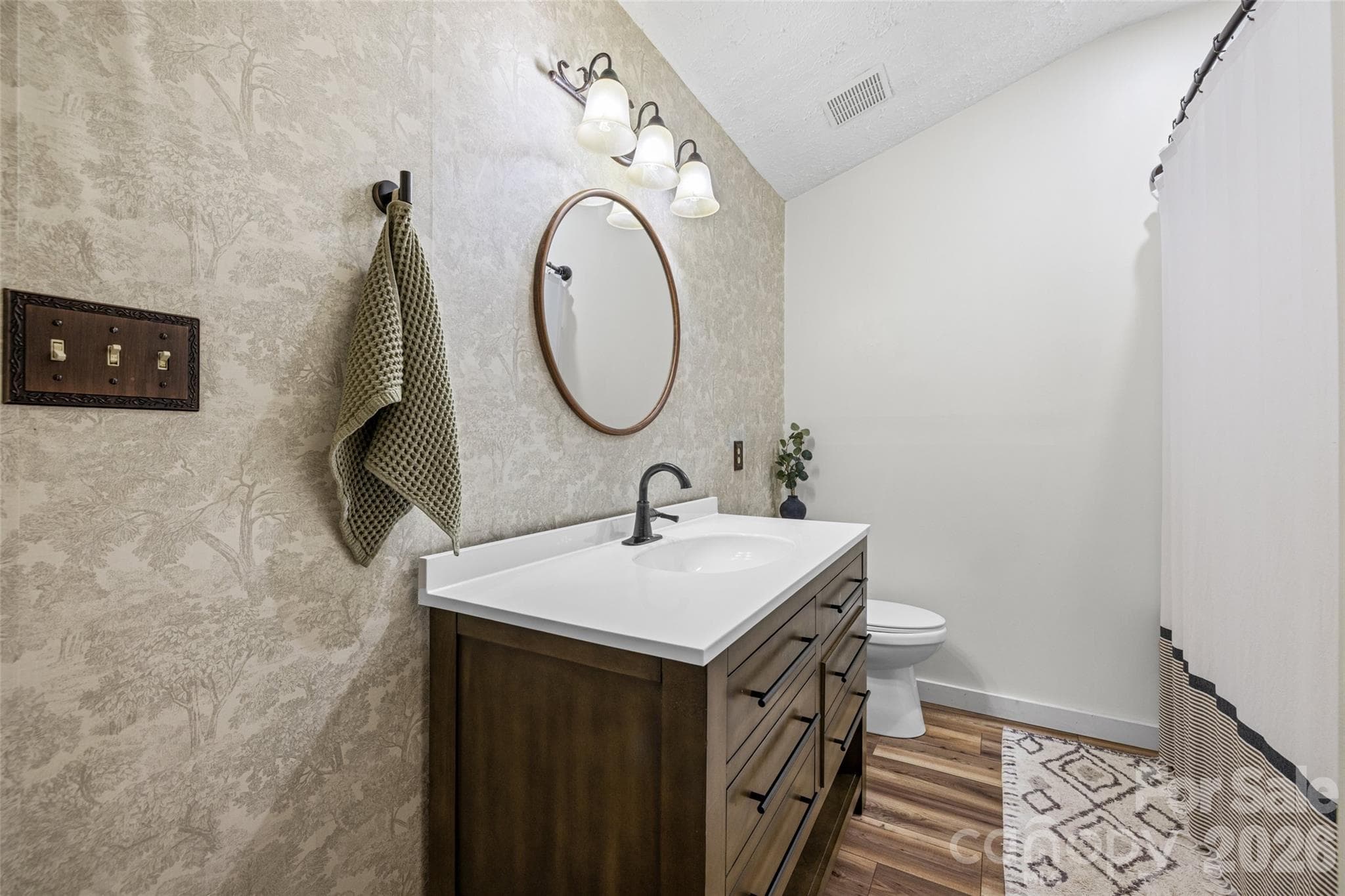 Beautifully updated bathroom featuring a new vanity, modern fixtures, stylish mirror, and updated lighting. - 231 E Jefferson Street, York