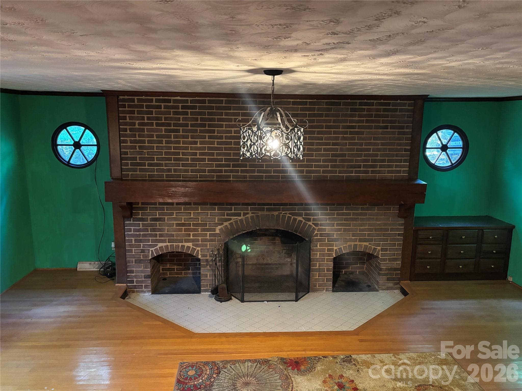 Large living room fireplace with built-in cabinet. - 5923 Stack Road, Monroe
