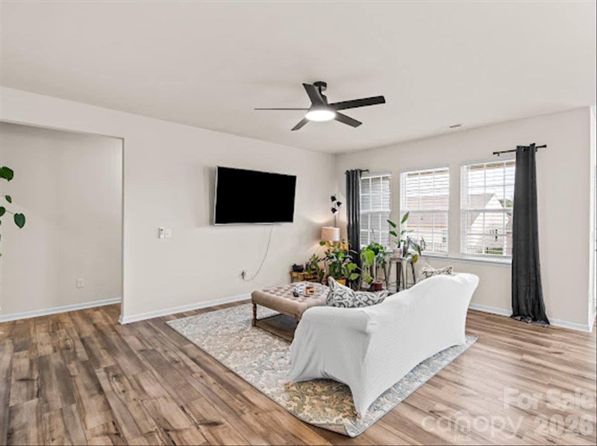 Alternate view of the living space highlighting the abundant natural light, gorgeous continuous flooring, and welcoming entryway. - 155 White Apple Way, Statesville