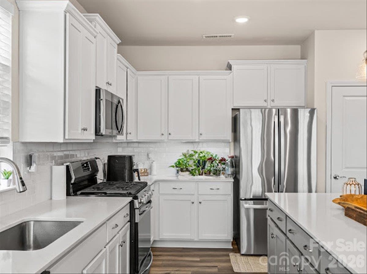 A chef's dream kitchen offering gorgeous countertops, ample storage space, and seamless flooring. - 155 White Apple Way, Statesville