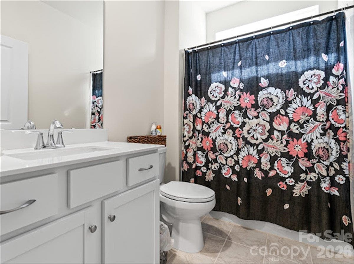 Bright and well-appointed secondary bathroom featuring a spacious vanity, large mirror, and a shower/tub combination. - 155 White Apple Way, Statesville