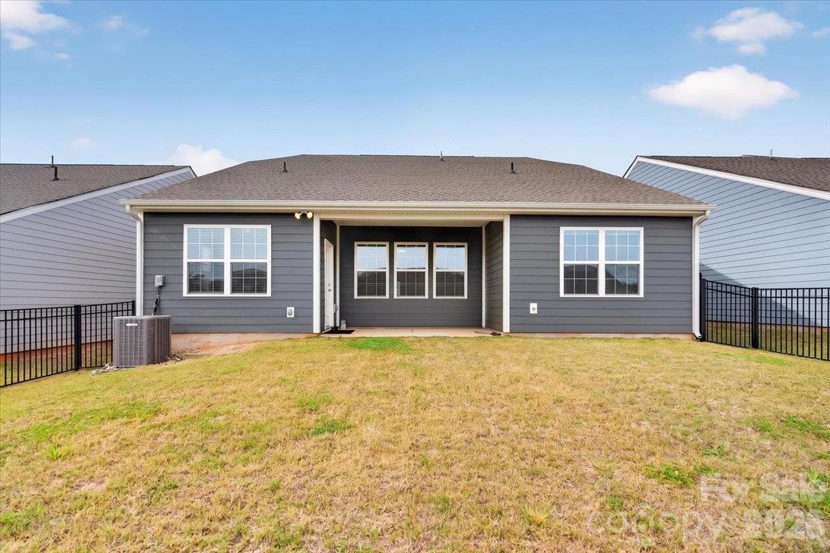 Rear view of the home highlighting the wonderful patio space and the extensive, private fenced-in yard. - 155 White Apple Way, Statesville