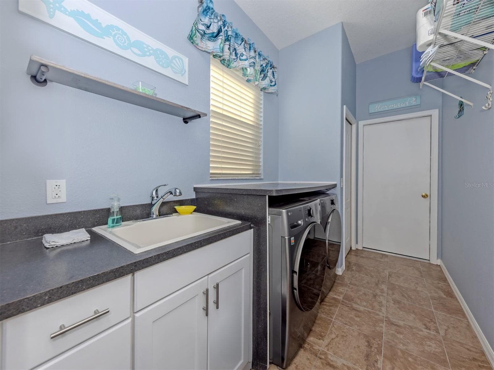Even laundry day feels a little brighter in this wonderful, dedicated laundry room! Complete with a window for natural light, a convenient utility sink, and a storage closet, this practical yet inviting space keeps everything neatly tucked away, with direct access to the spacious two-car garage! - 443 BERMUDA ISLES CIR, VENICE