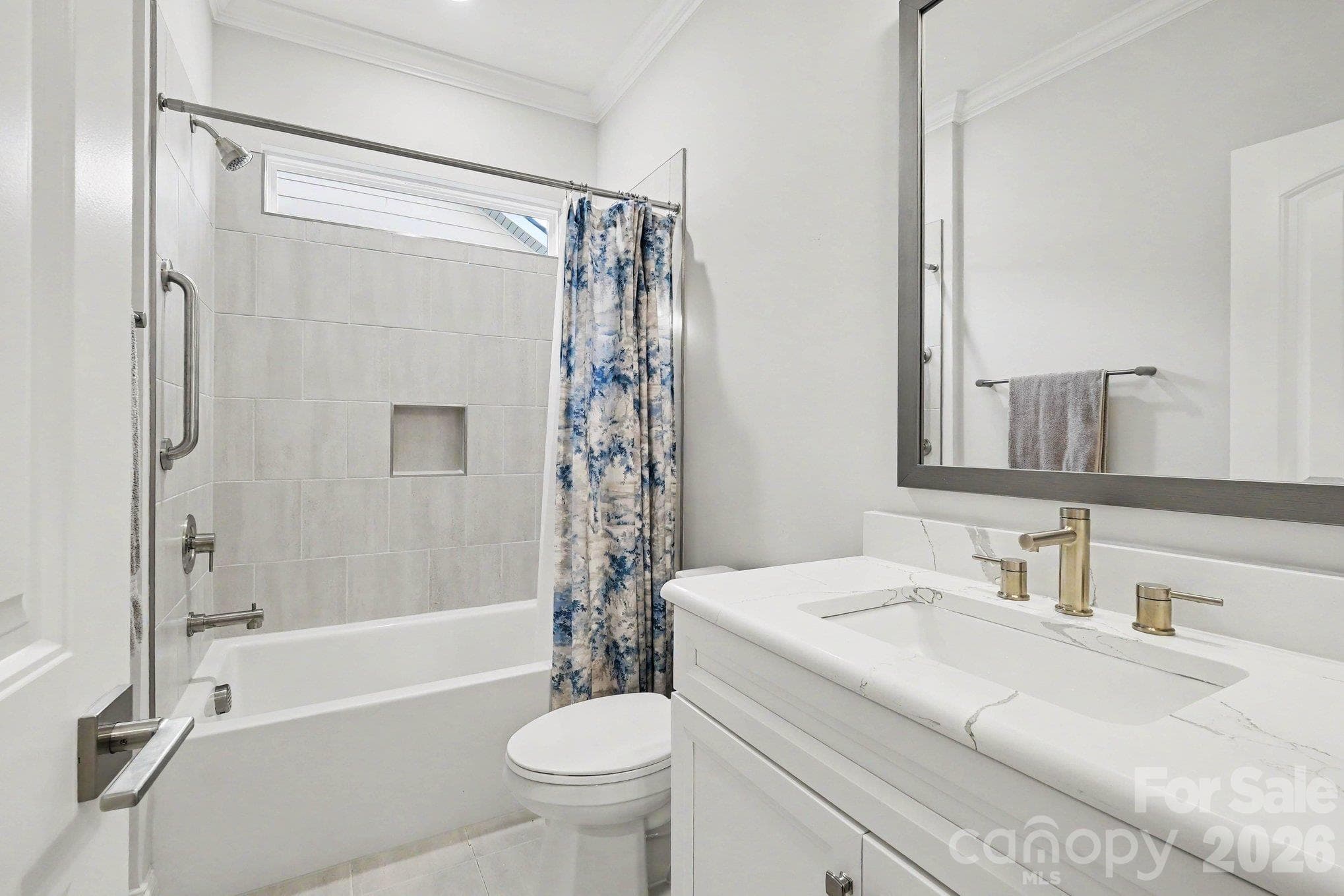 Main floor bathroom with built-ins and tiled tub surround - 5605 Caneel Lane, Denver