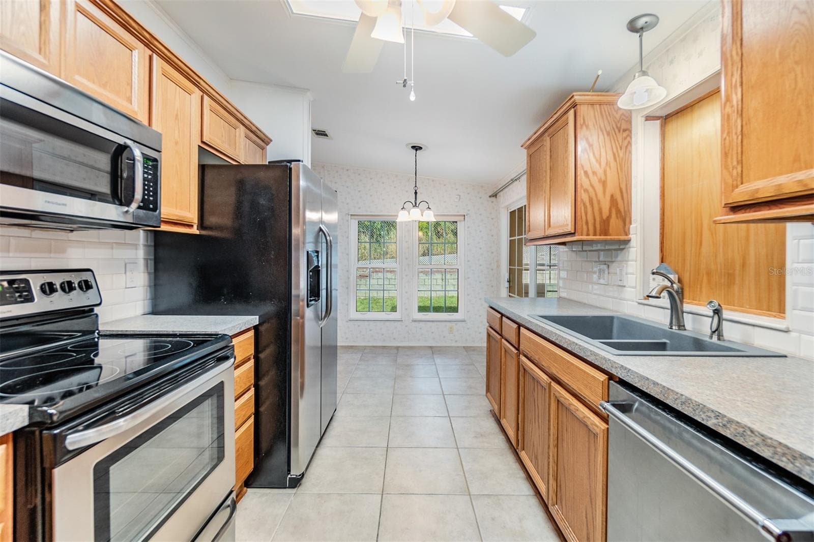 Updated kitchen with wood cabinets and stainless appliances - 37449 GILL AVE, ZEPHYRHILLS