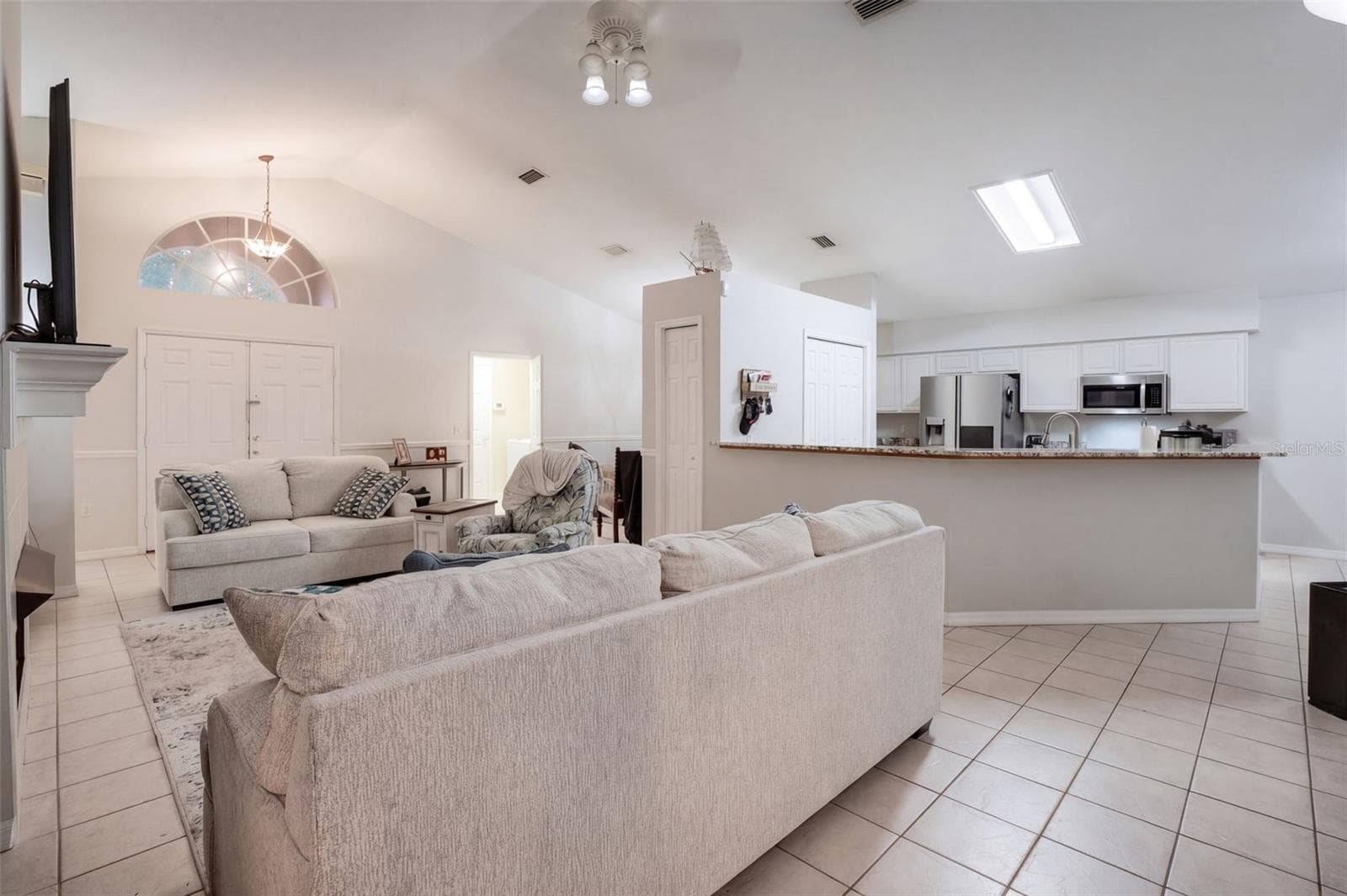 An open sightline from the living room into the kitchen makes the floor plan feel spacious and social. - 71 ORANGE BLOSSOM DR, EUSTIS