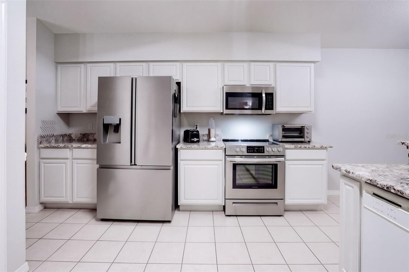 Stainless steel appliances complement the bright white cabinetry. - 71 ORANGE BLOSSOM DR, EUSTIS