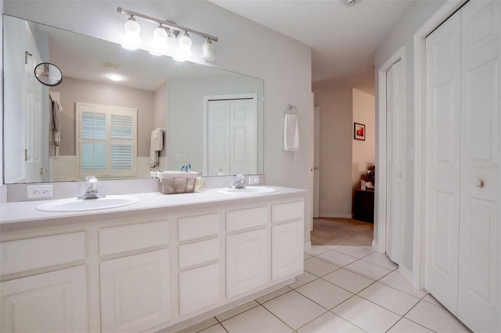 The primary bathroom features dual vanities and generous storage. - 71 ORANGE BLOSSOM DR, EUSTIS