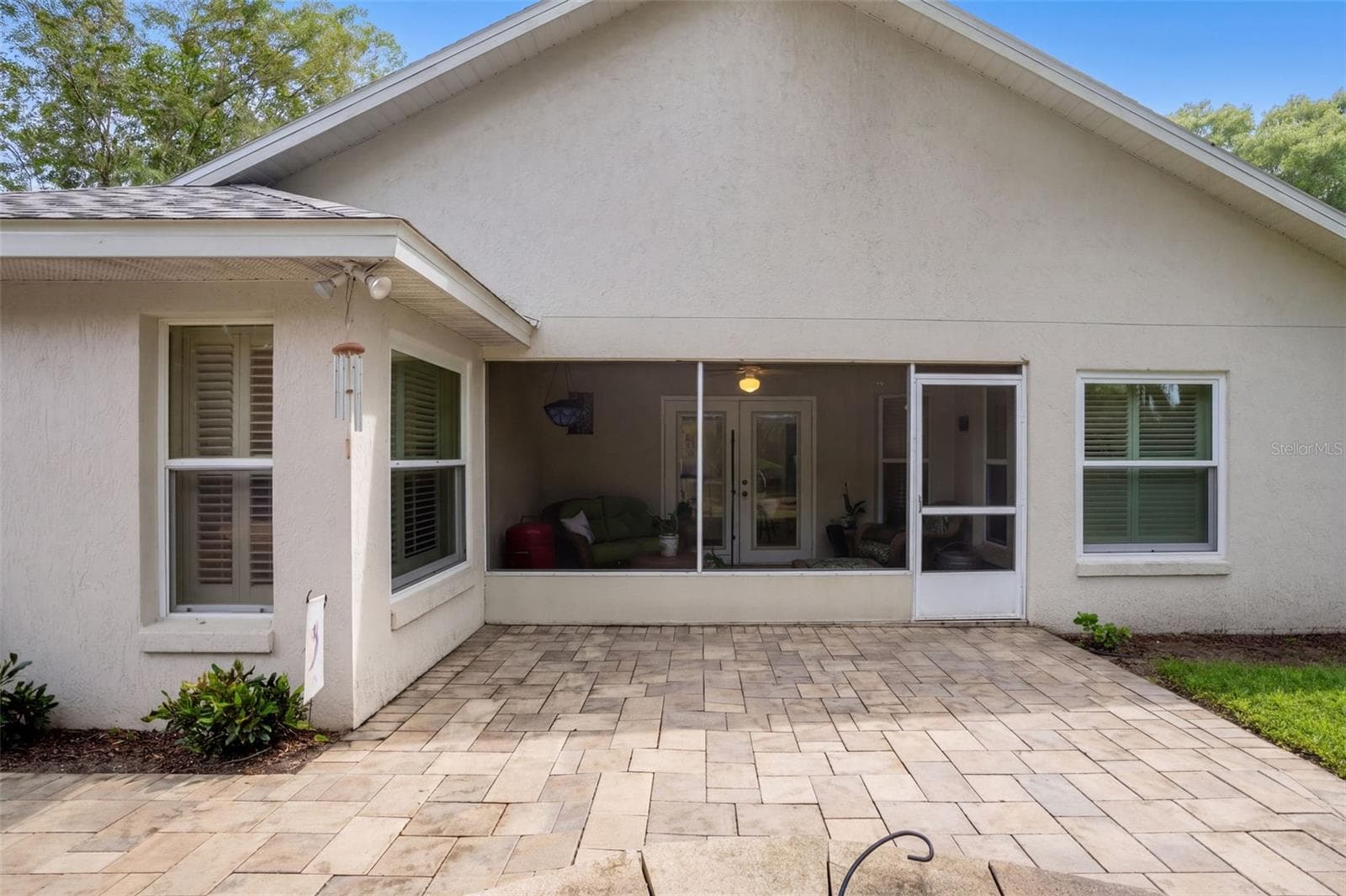 The rear elevation opens to an expansive brick-paver patio. - 71 ORANGE BLOSSOM DR, EUSTIS