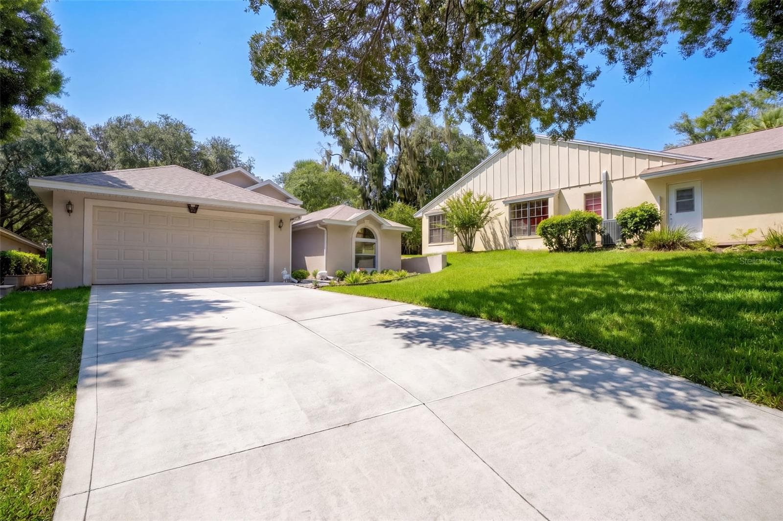 A second front angle shows the driveway, two-car garage, and welcoming covered entry. - 71 ORANGE BLOSSOM DR, EUSTIS