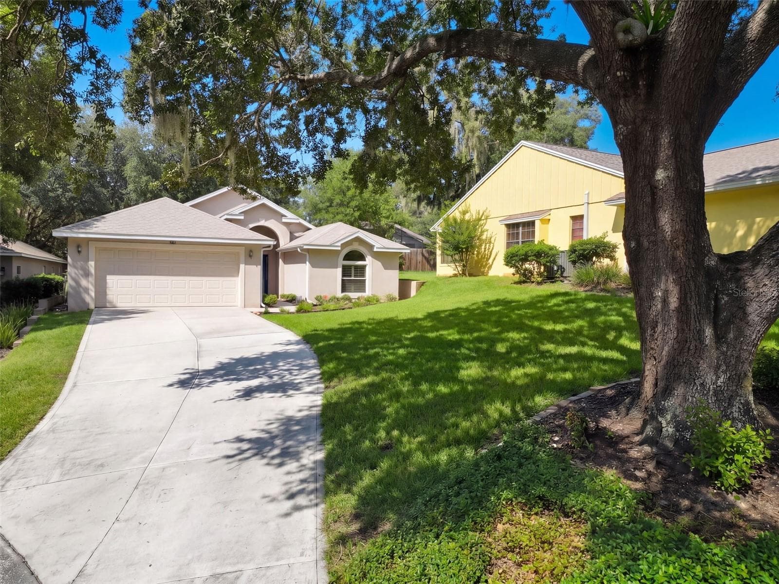 A wider curbside view captures the home and its established setting. - 71 ORANGE BLOSSOM DR, EUSTIS