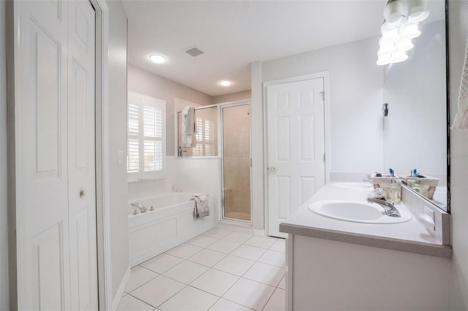 The primary bath pairs a garden tub with a long vanity and ample cabinet storage. - 71 ORANGE BLOSSOM DR, EUSTIS