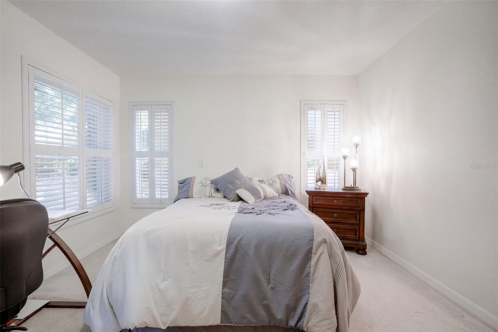 A second angle of the guest bedroom shows its natural light and useful wall space. - 71 ORANGE BLOSSOM DR, EUSTIS