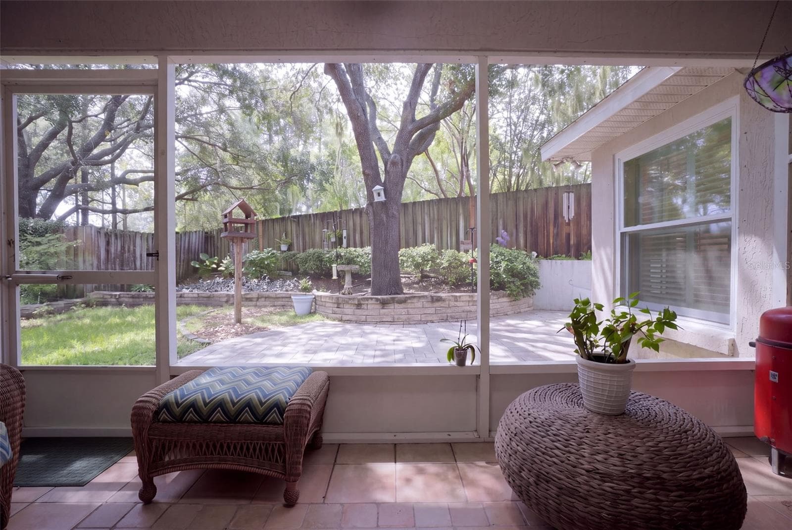 The screened porch overlooks the landscaped backyard and paver patio. - 71 ORANGE BLOSSOM DR, EUSTIS