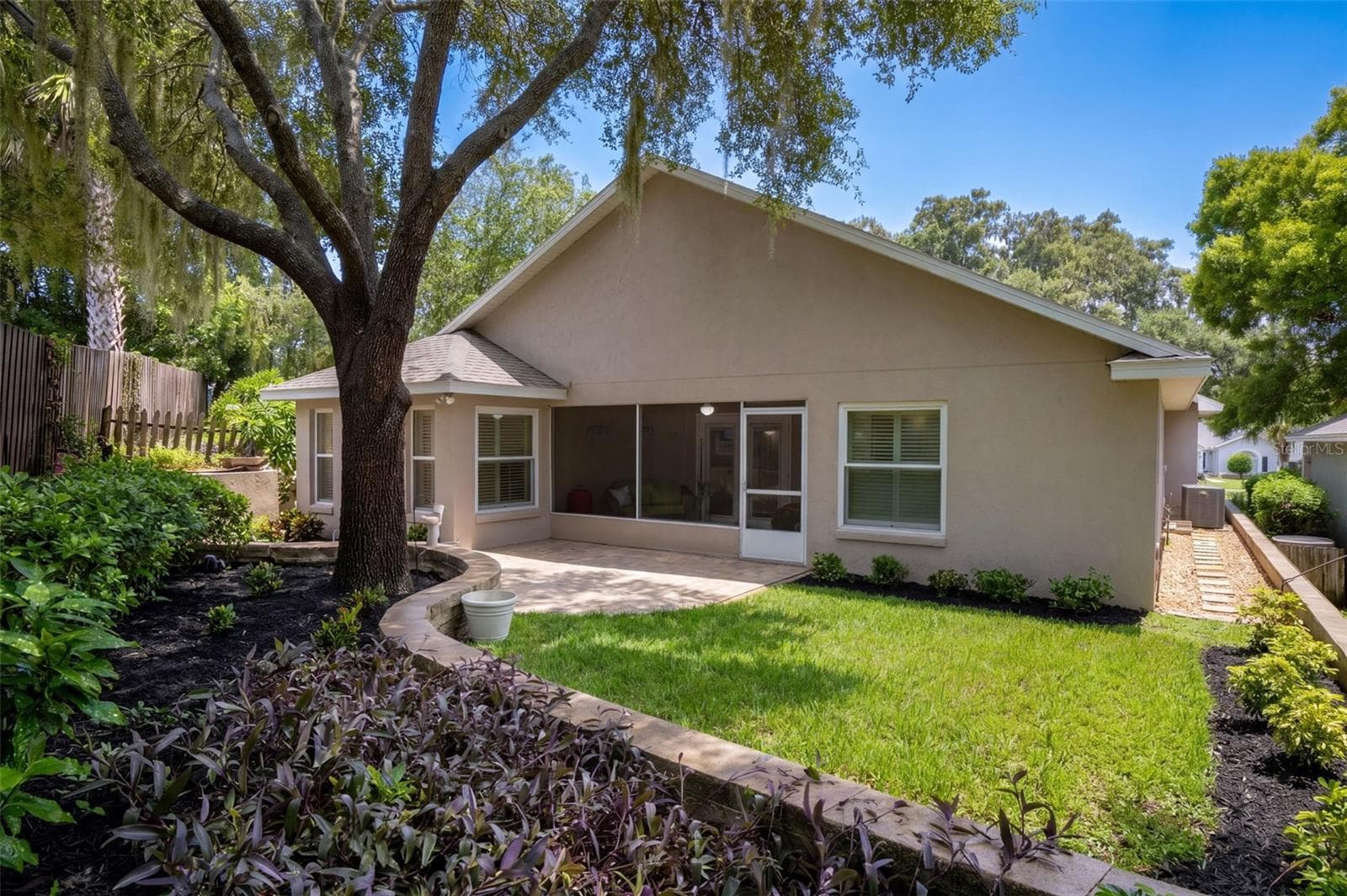 The rear yard offers multiple outdoor zones for dining, gardening, and relaxing. - 71 ORANGE BLOSSOM DR, EUSTIS