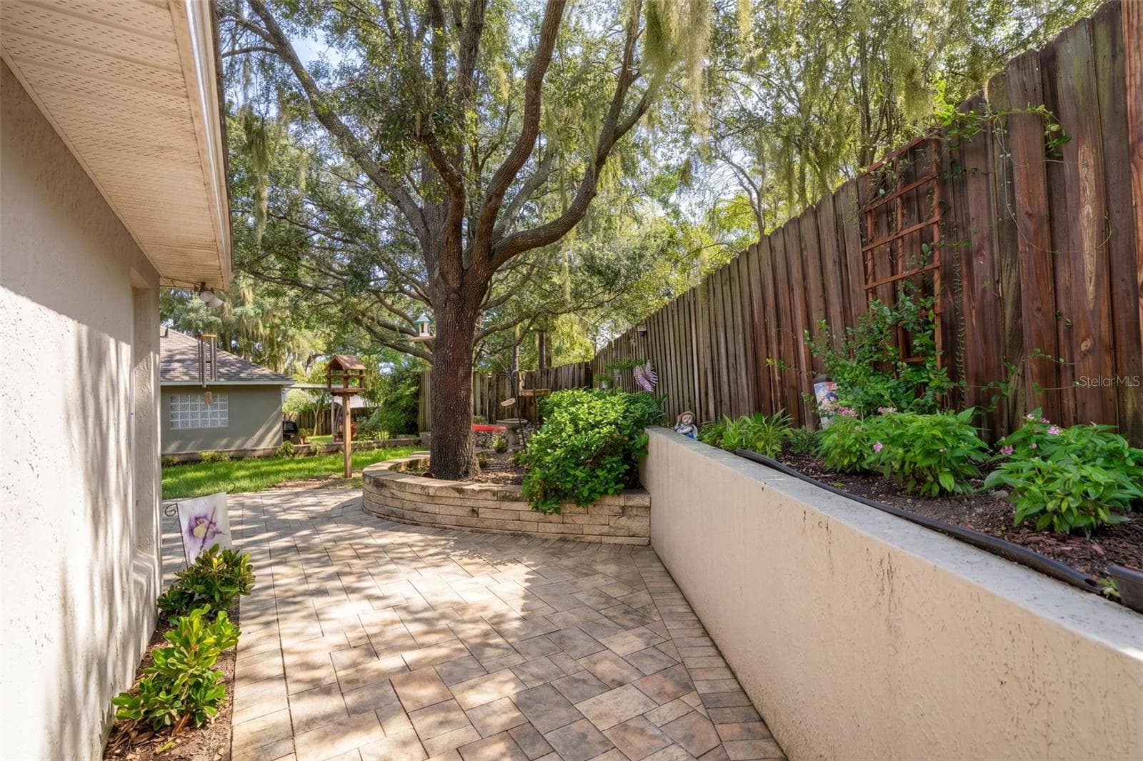 Raised planting beds and brick pavers add texture and character along the side yard. - 71 ORANGE BLOSSOM DR, EUSTIS