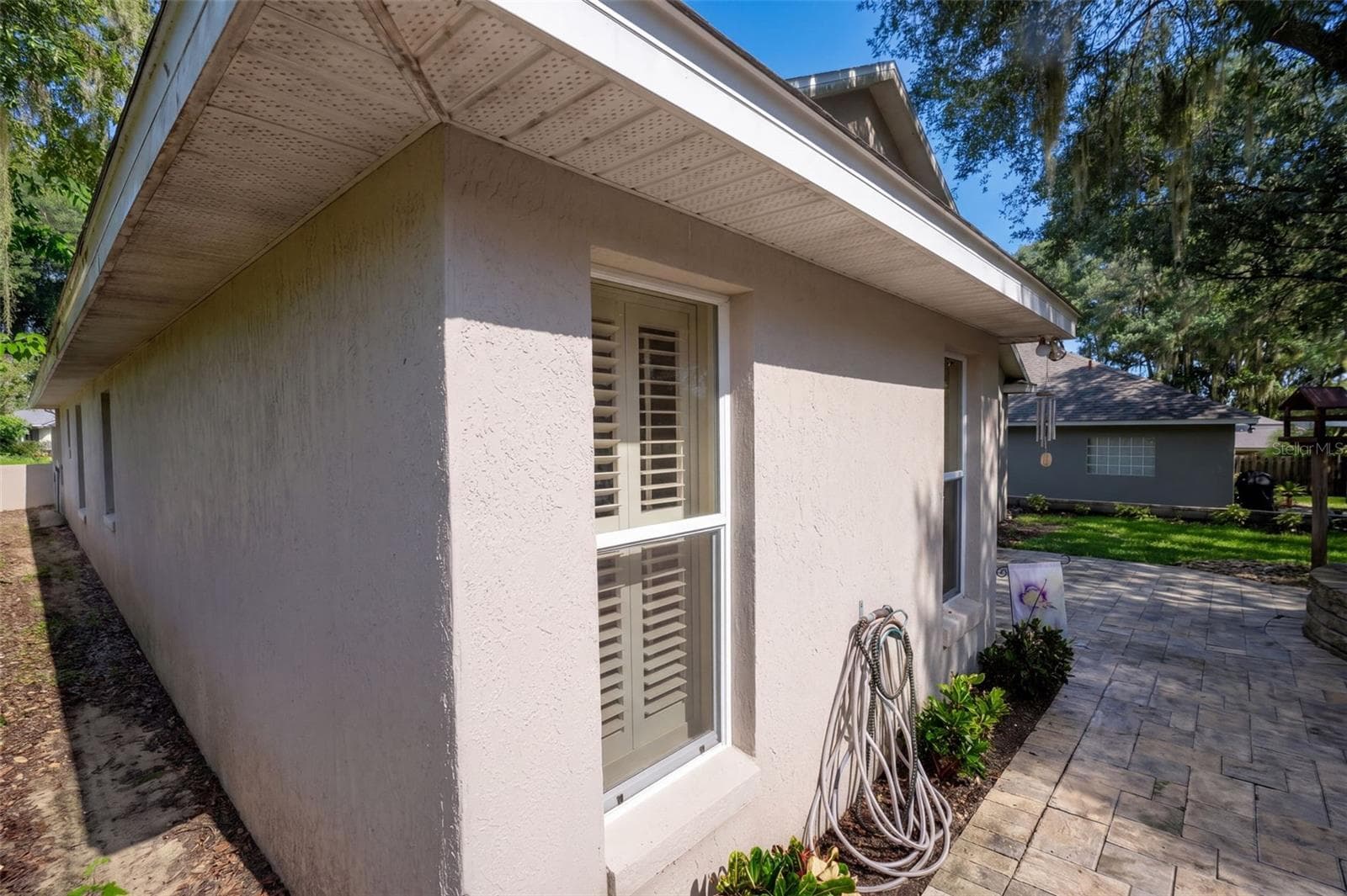 A brick-paver walkway connects the front and rear outdoor spaces. - 71 ORANGE BLOSSOM DR, EUSTIS