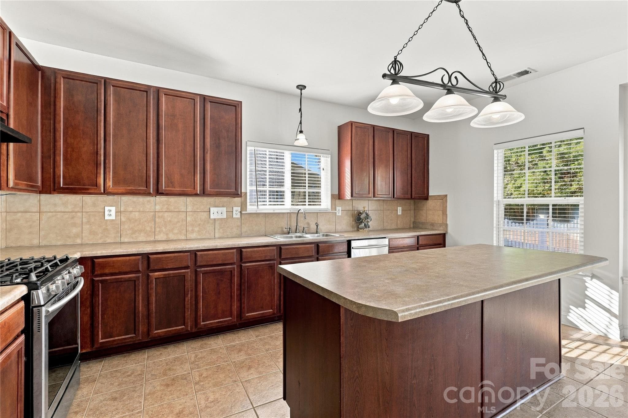 Rich cabinetry, a tile backsplash, and a large island give you plenty of room to cook and gather. - 327 Annaberg Lane, Monroe