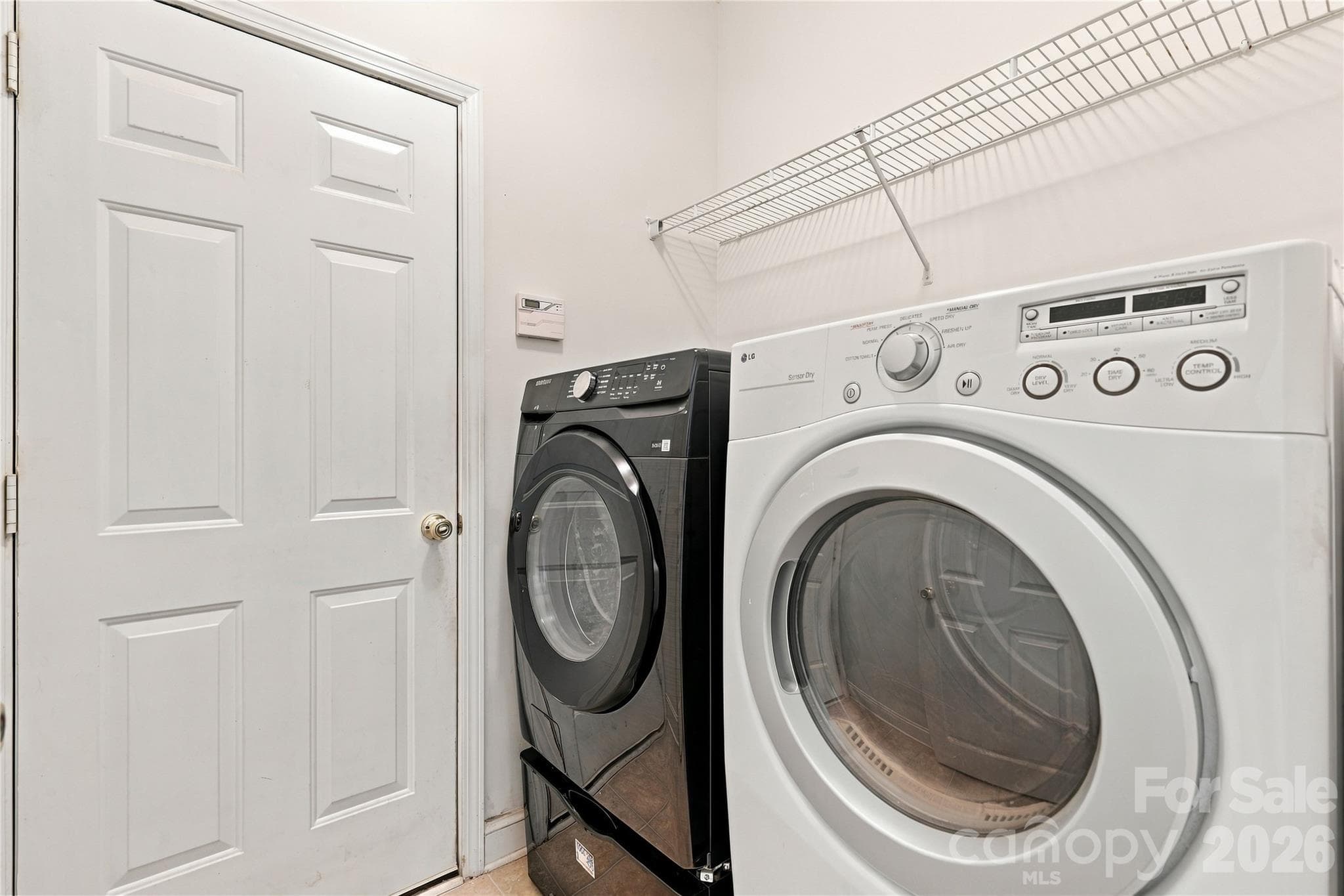 The laundry room has shelving and is located just off the garage for easy everyday chores. - 327 Annaberg Lane, Monroe