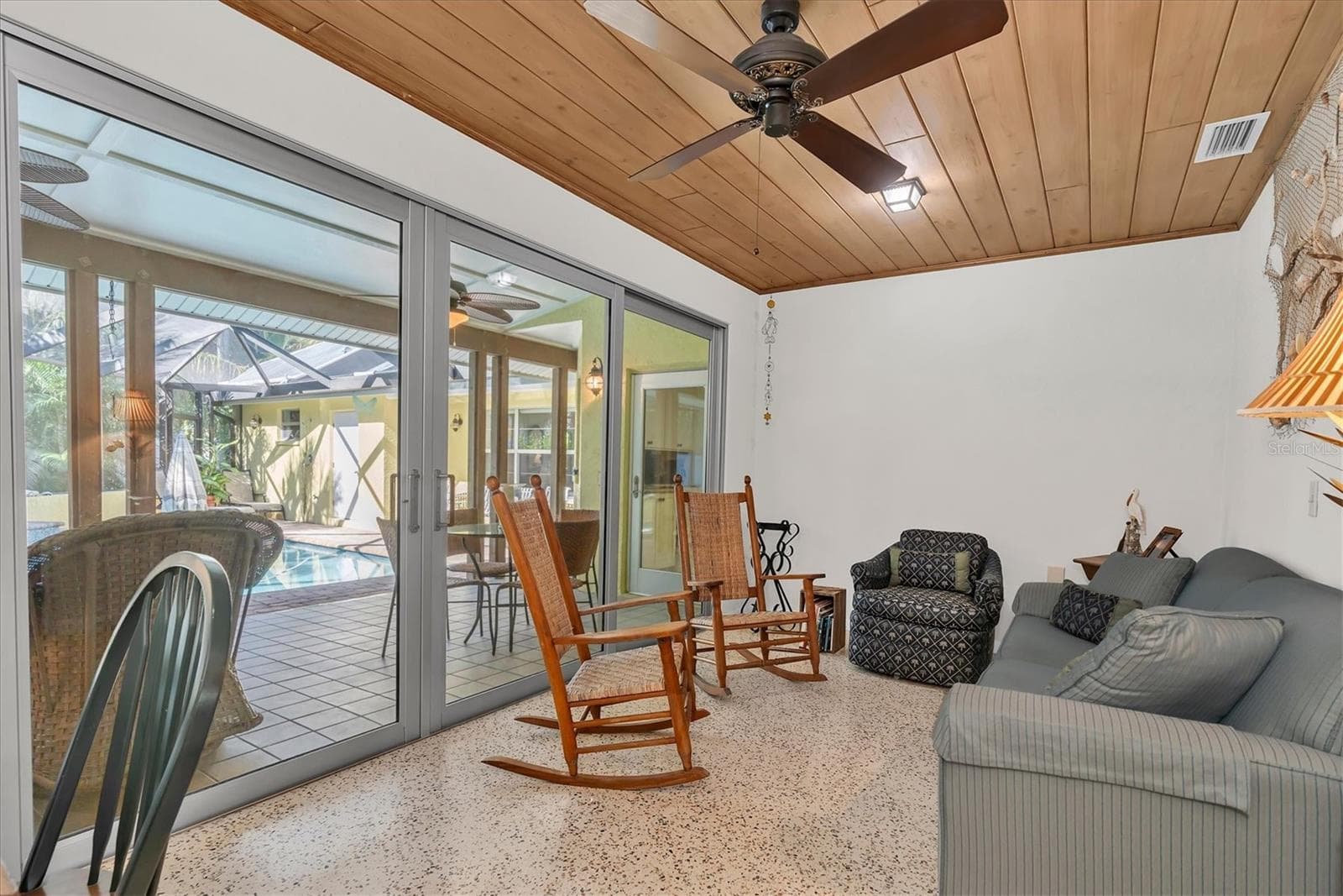 Sliders off Florida room open to large covered outdoor dining, cooking and entertaining space - 7106 PALM DR, HOLMES BEACH