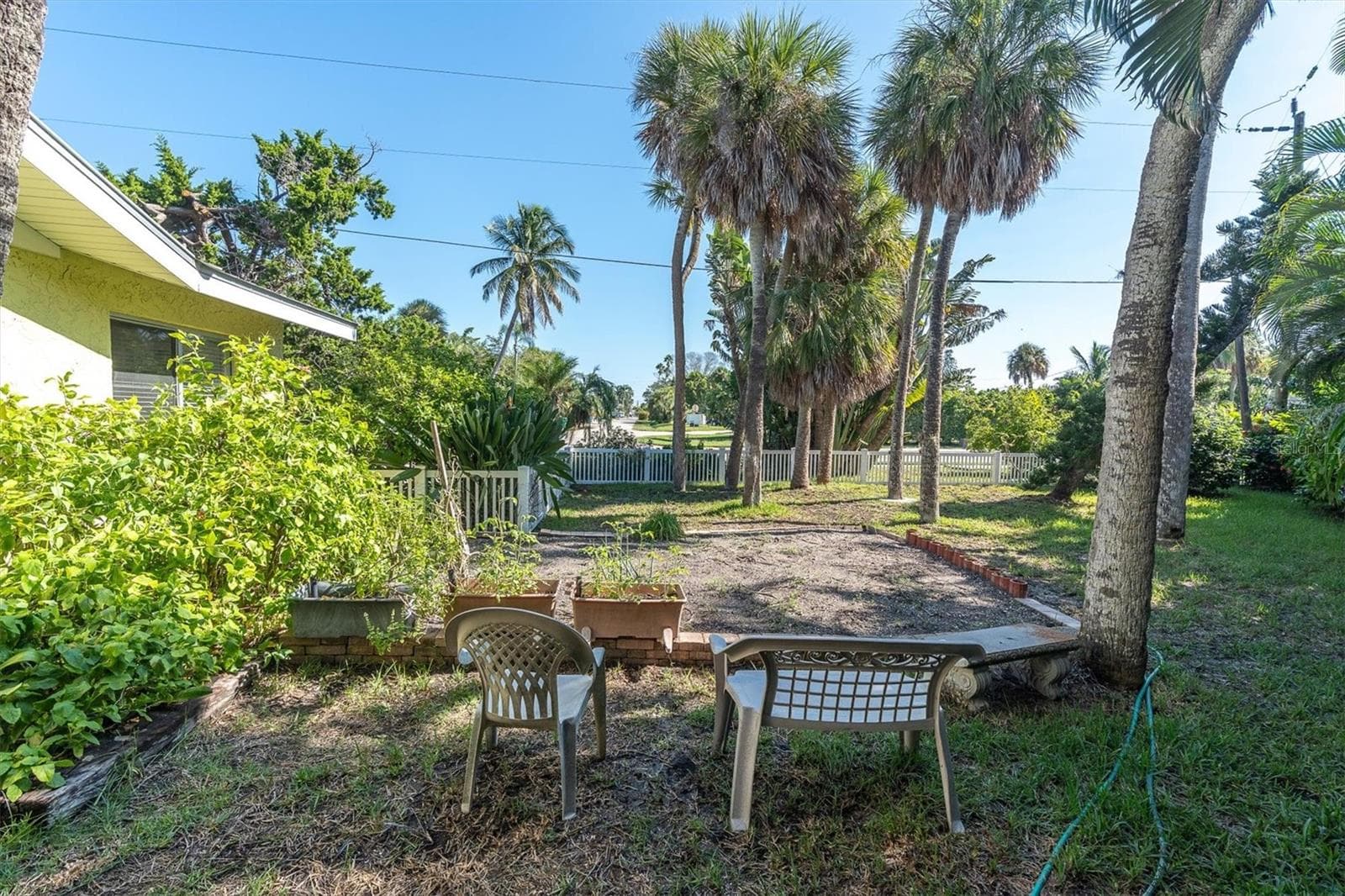 Large side yard with garden space, room for the kids and dogs to play or a game of cornhole. Lot size is 9,424 square feet if you want to renovate or teardown and build new. - 7106 PALM DR, HOLMES BEACH