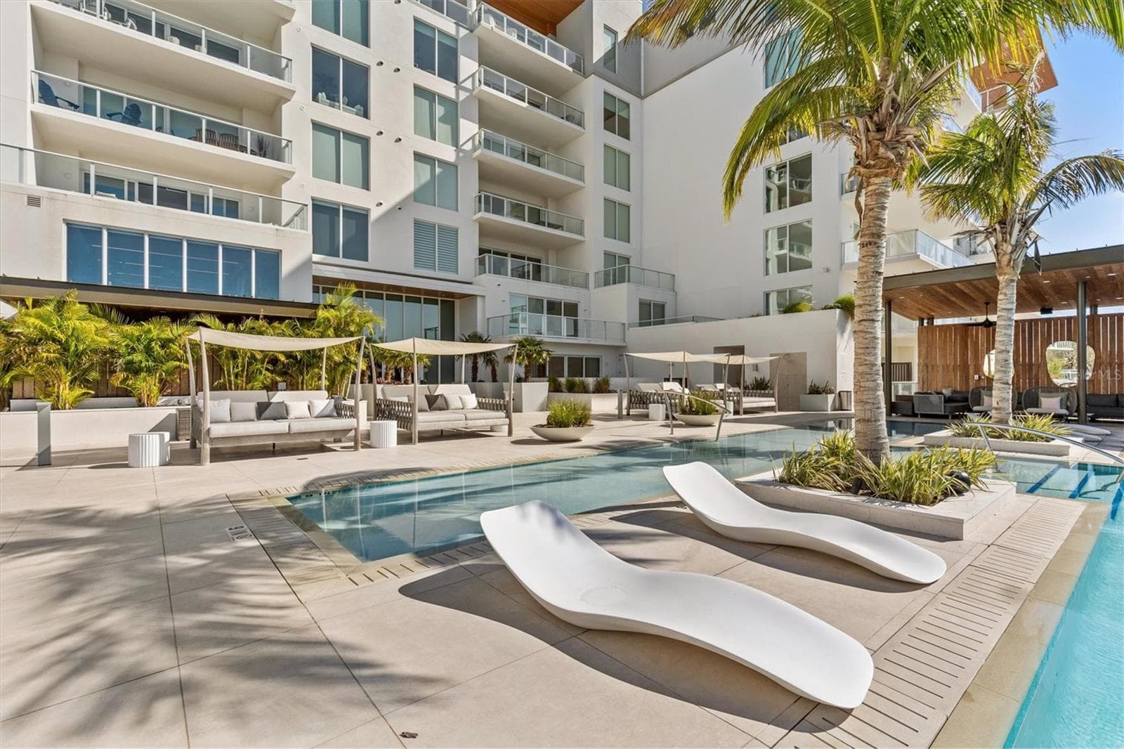 pool lounging area with cabanas - 1020 SUNSET POINT RD #112, CLEARWATER