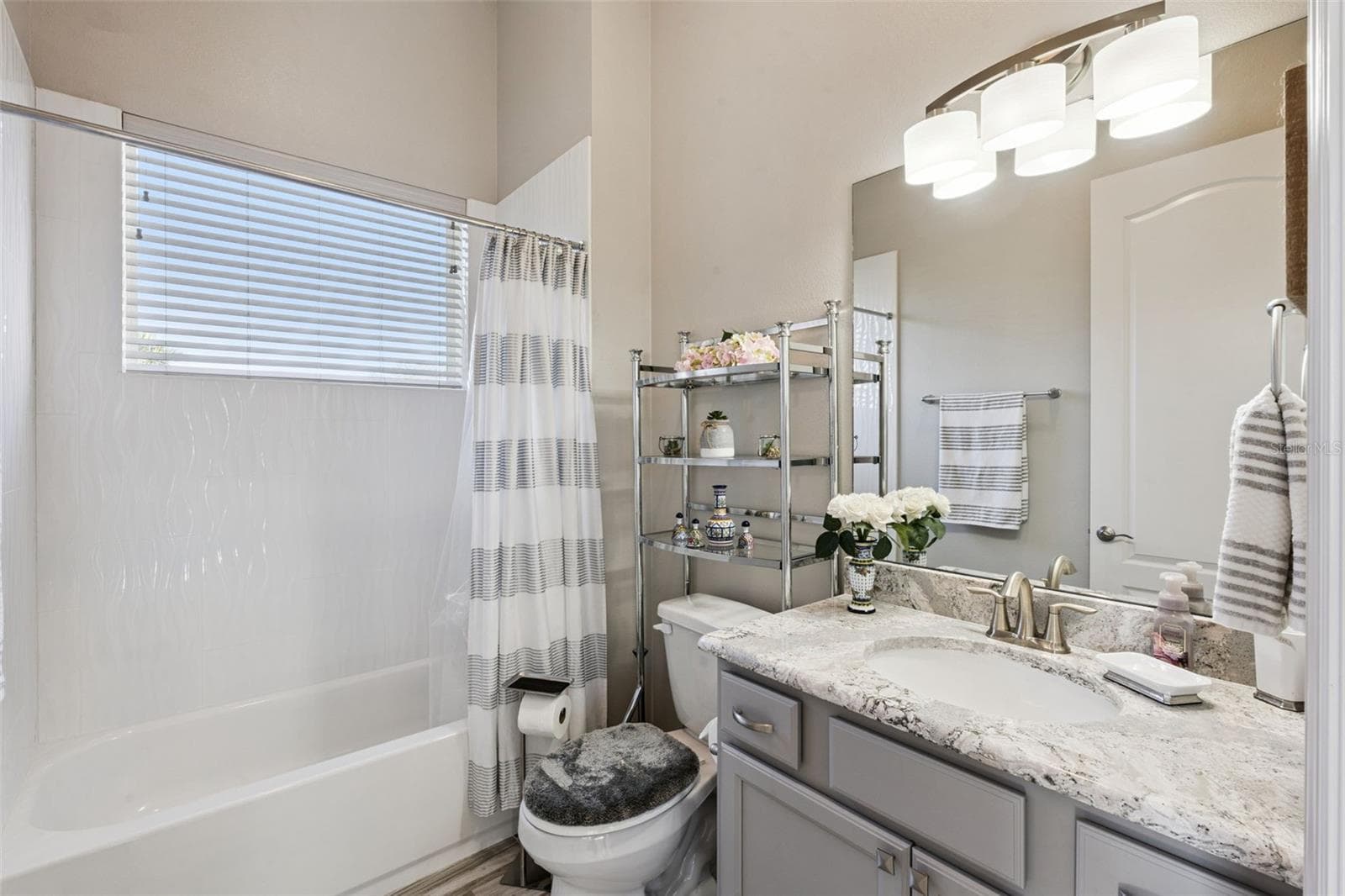 Bedroom 4/in law suite includes an en suite bathroom with shower/tub combo and quartz counters - 36819 WOLF CT, EUSTIS