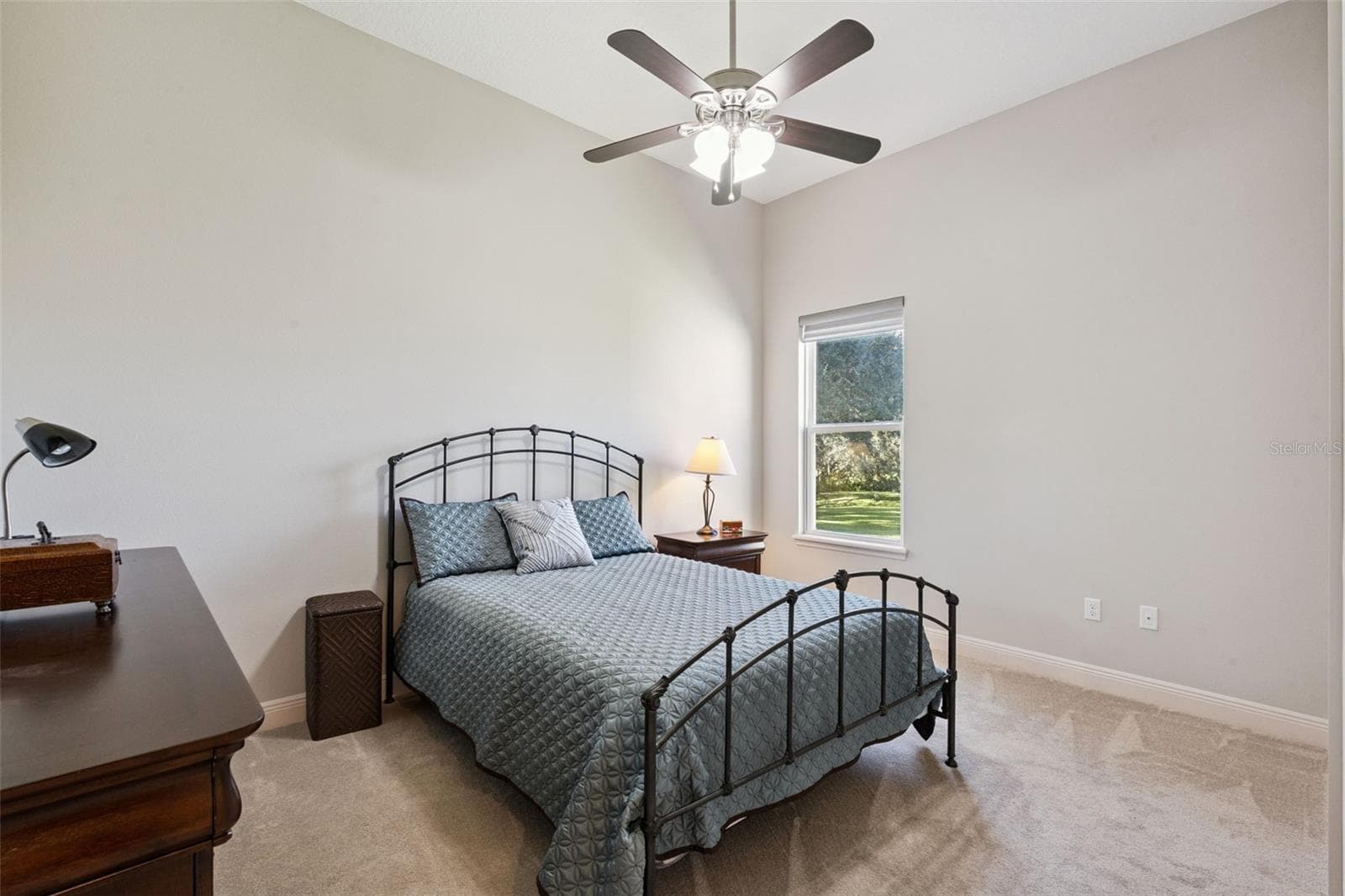 Bedroom 3 features a spacious walk-in closet, a ceiling fan for climate control, and a neutral paint palette that serves as a perfect blank canvas for any décor style. - 36819 WOLF CT, EUSTIS